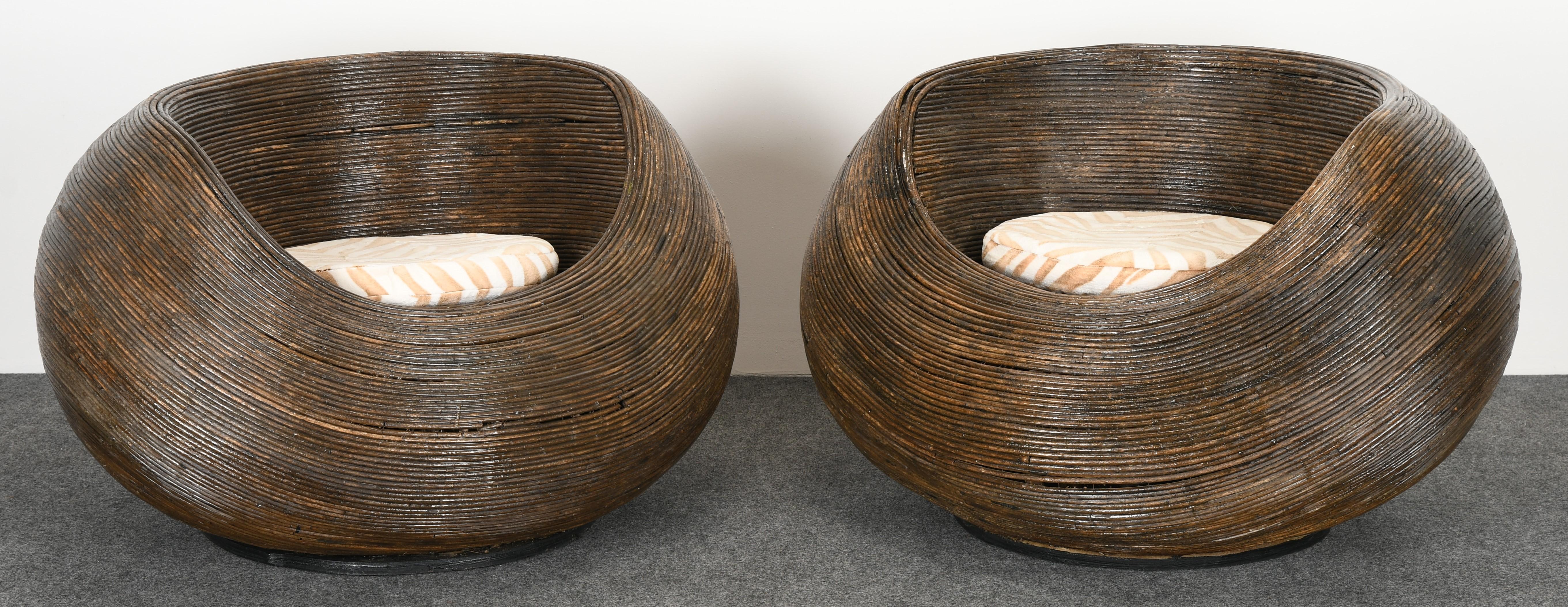 A pair of rattan pod lounge chairs. These chairs have great style and we believe they are vintage but are unsure of age. Some damage to rattan, as shown in images, which may need restoration.

Dimensions: 25