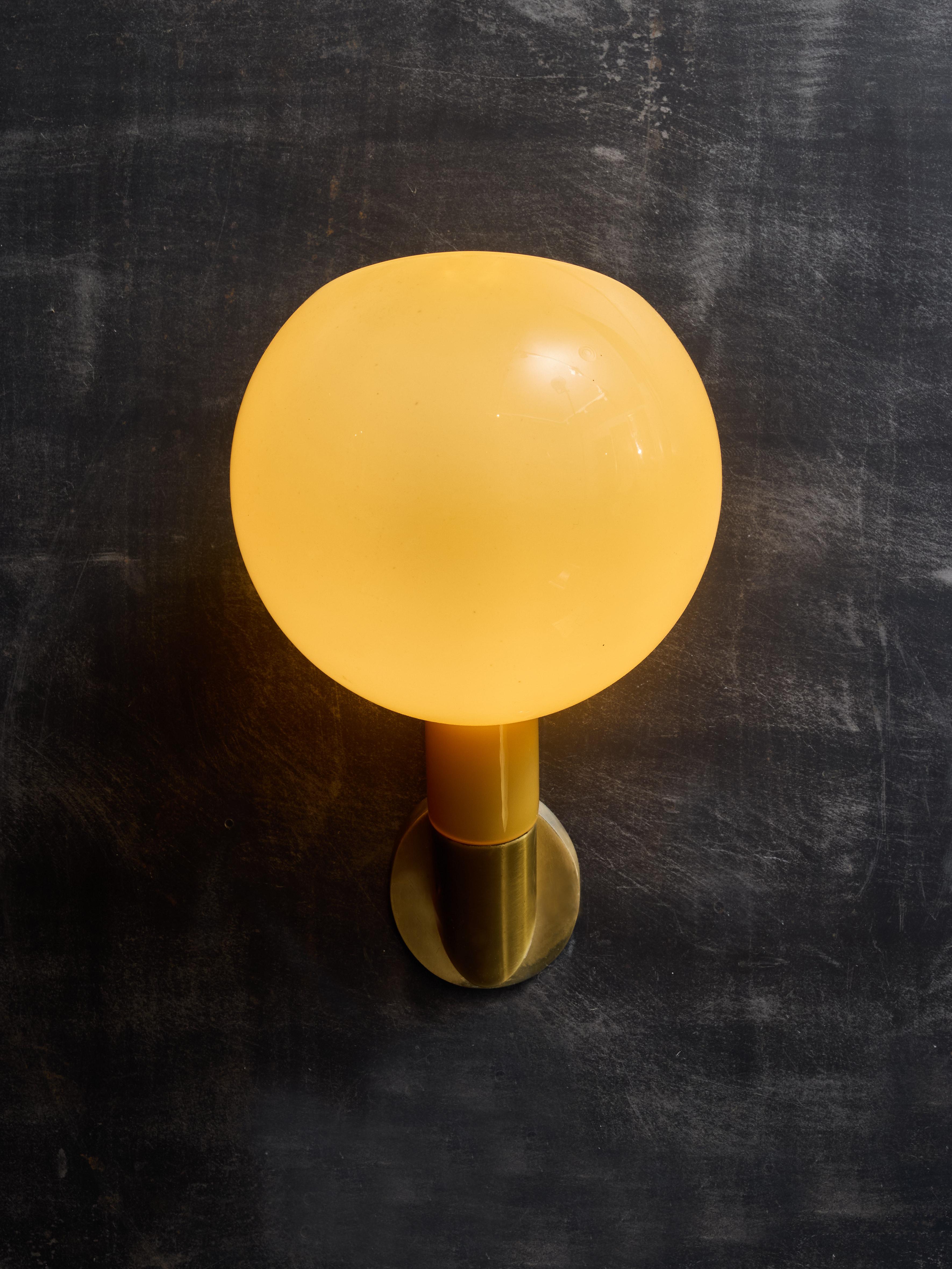 Pair of beautiful wall sconces model 2689 designed by Gae Aulenti and Piero Castiglioni for Fontana Arte, circa 1981.
The sconces are made of a brass wall bracket holding one source of light, and a glass sconce sleeved onto the brass holder. The