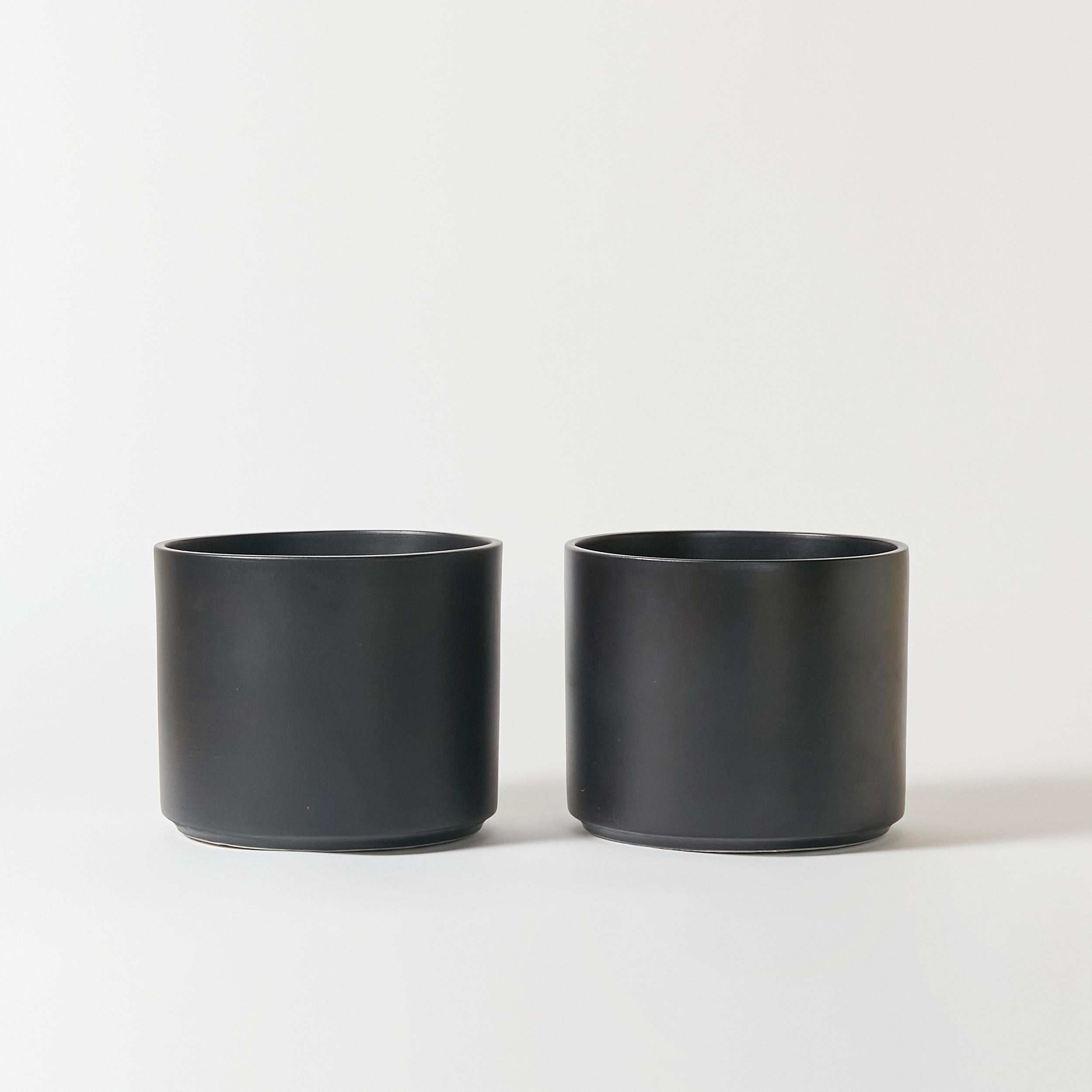 Set of two architectural pottery planters finished in satin black glaze. Signed Gainey on the bottom. Made in California in 1960s.
This items pair perfectly with our Gainey tall black planter. Our reference 23.0084A