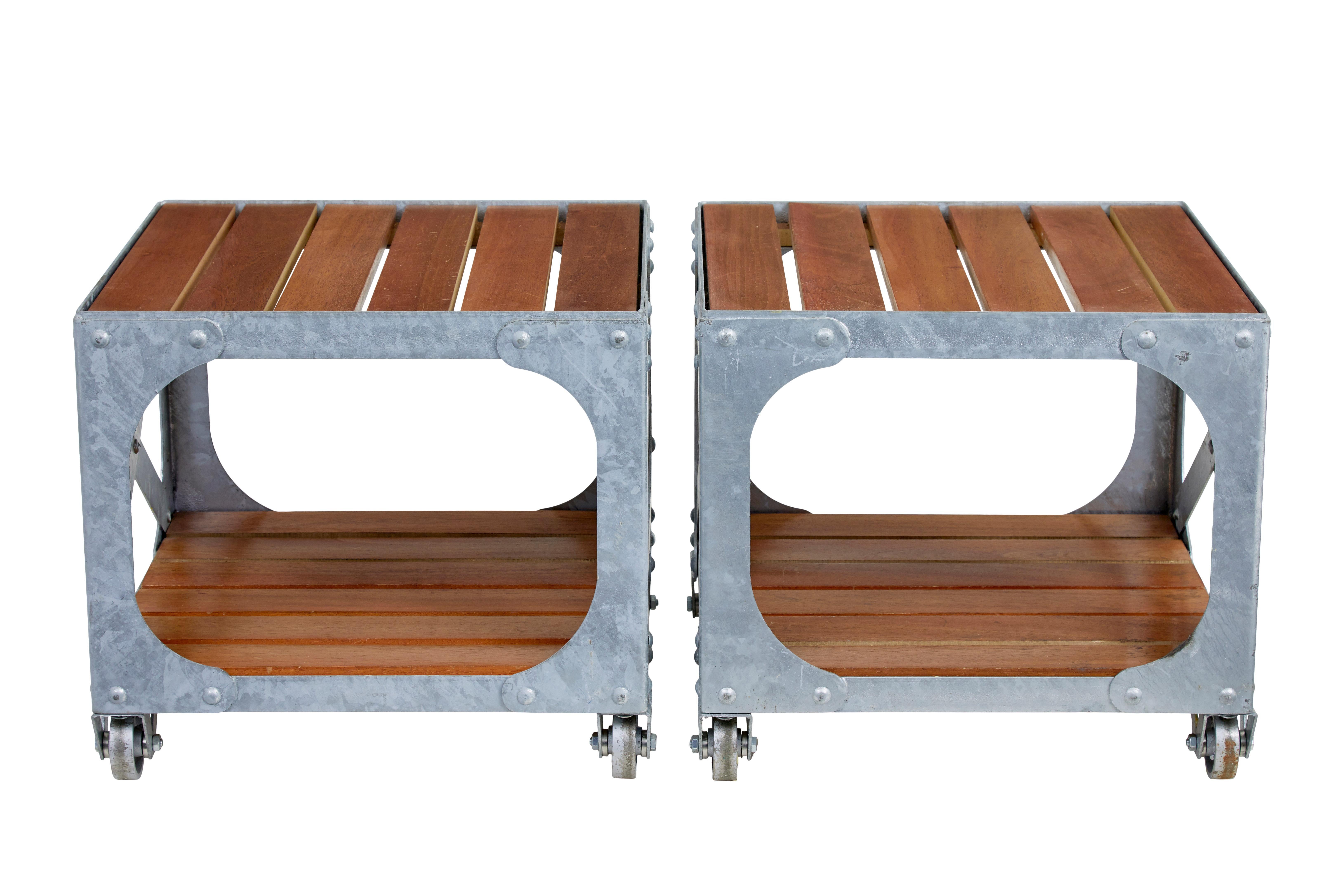 Paire de tables d'appoint industrielles en acier galvanisé et en teck, vers 1990.

Paire de tables d'inspiration industrielle de bonne qualité en acier galvanisé avec des lattes insérées en teck.  S'intègre parfaitement dans un intérieur ou un