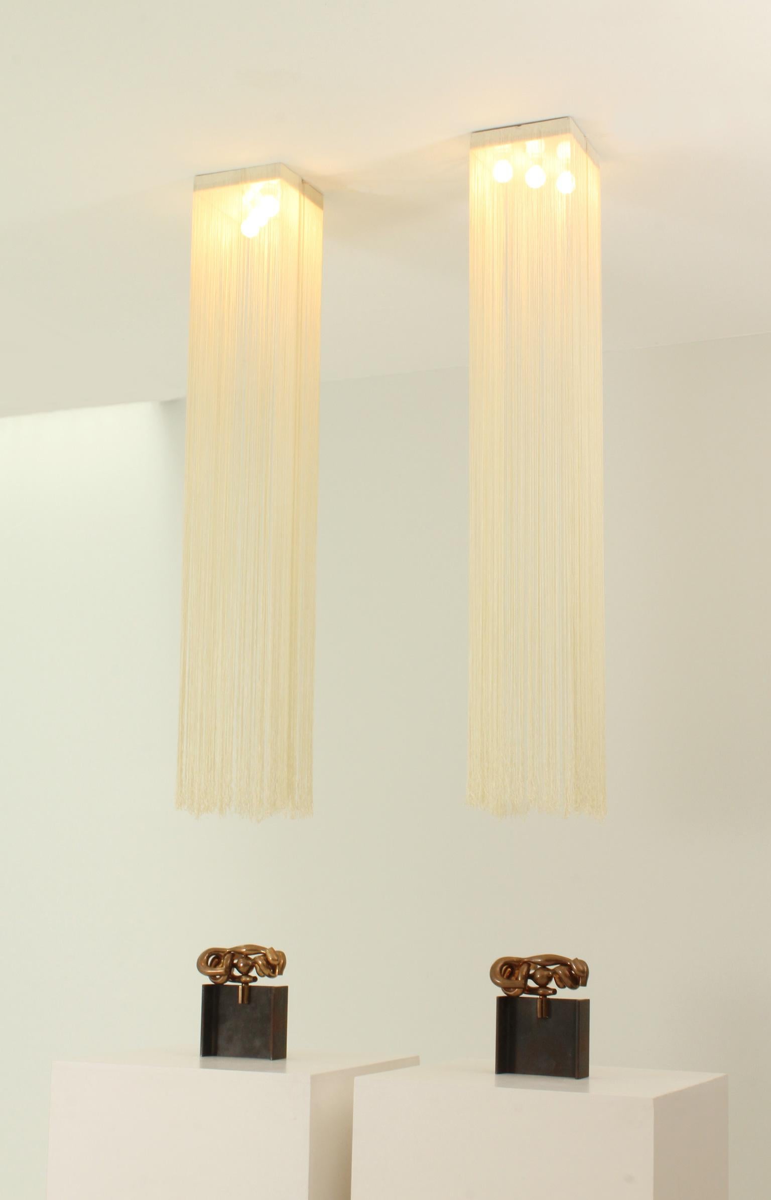 A pair of Garbo ceiling lamps designed in 1976 by Mariyo Yagi and Studio Simon for Sirrah, Italy. Metal lacquered structure with three bulbs that supports a curtain of nylon fabric rope.