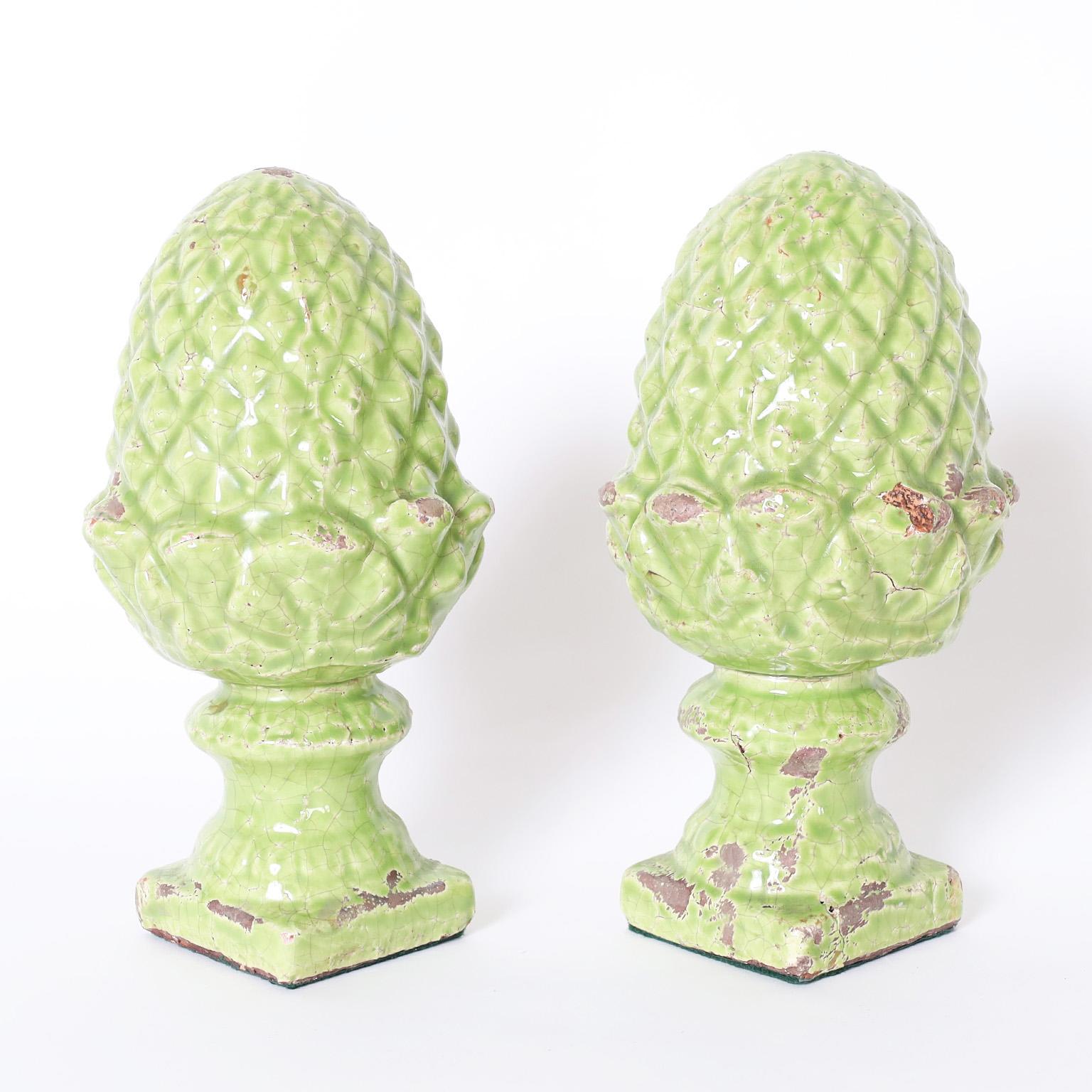 Standout pair of English pineapple finials crafted in terra cotta decorated in a delightful green and glazed, now perfectly worn and crackled.