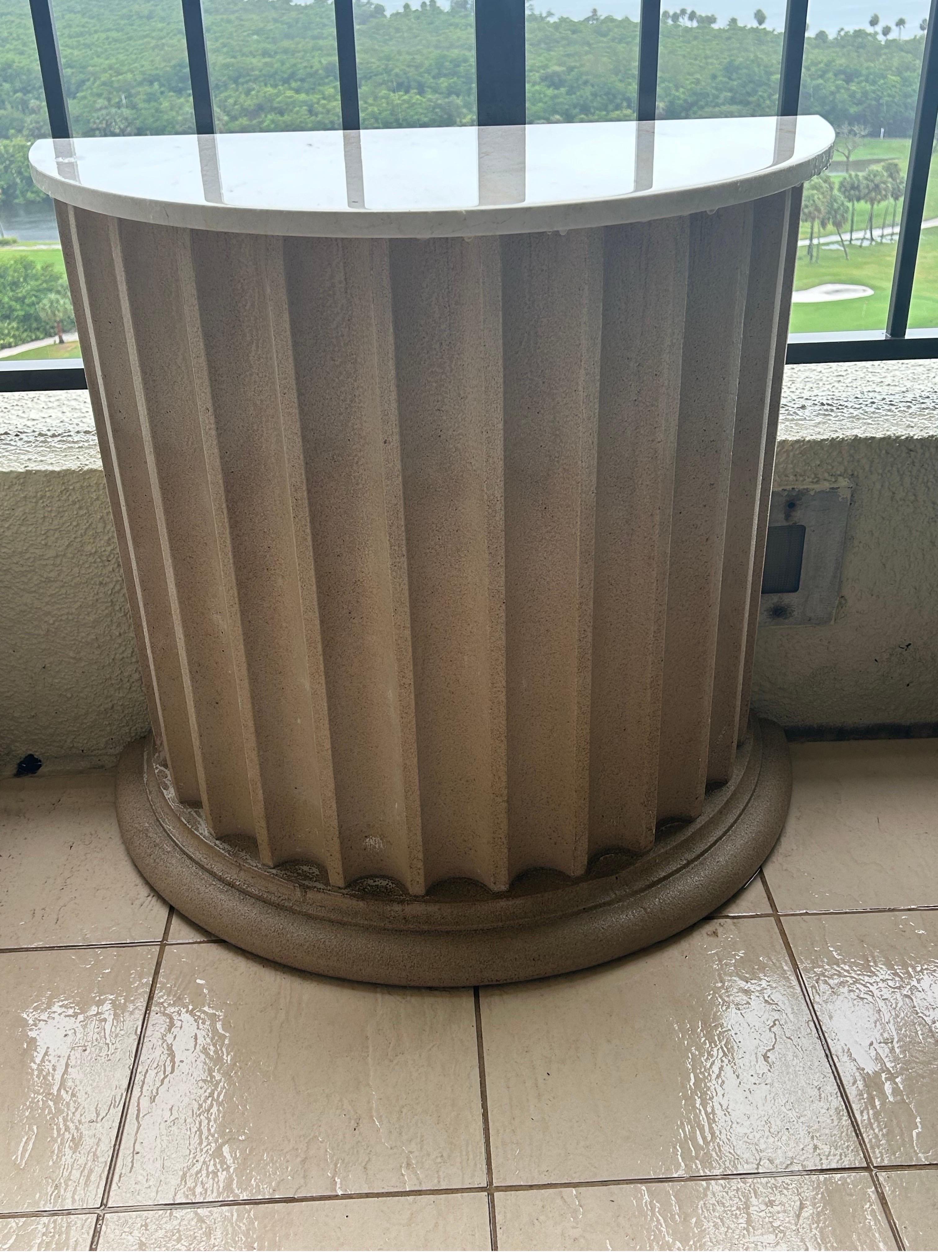 A pair of cast sandstone Garden tables… Demi-lune bases… Topped with white marble … These have been used as exterior decoration for years… They measure 33 inches wide by 18 inches deep by 28 inches tall… They can be used as tables or as pedestals