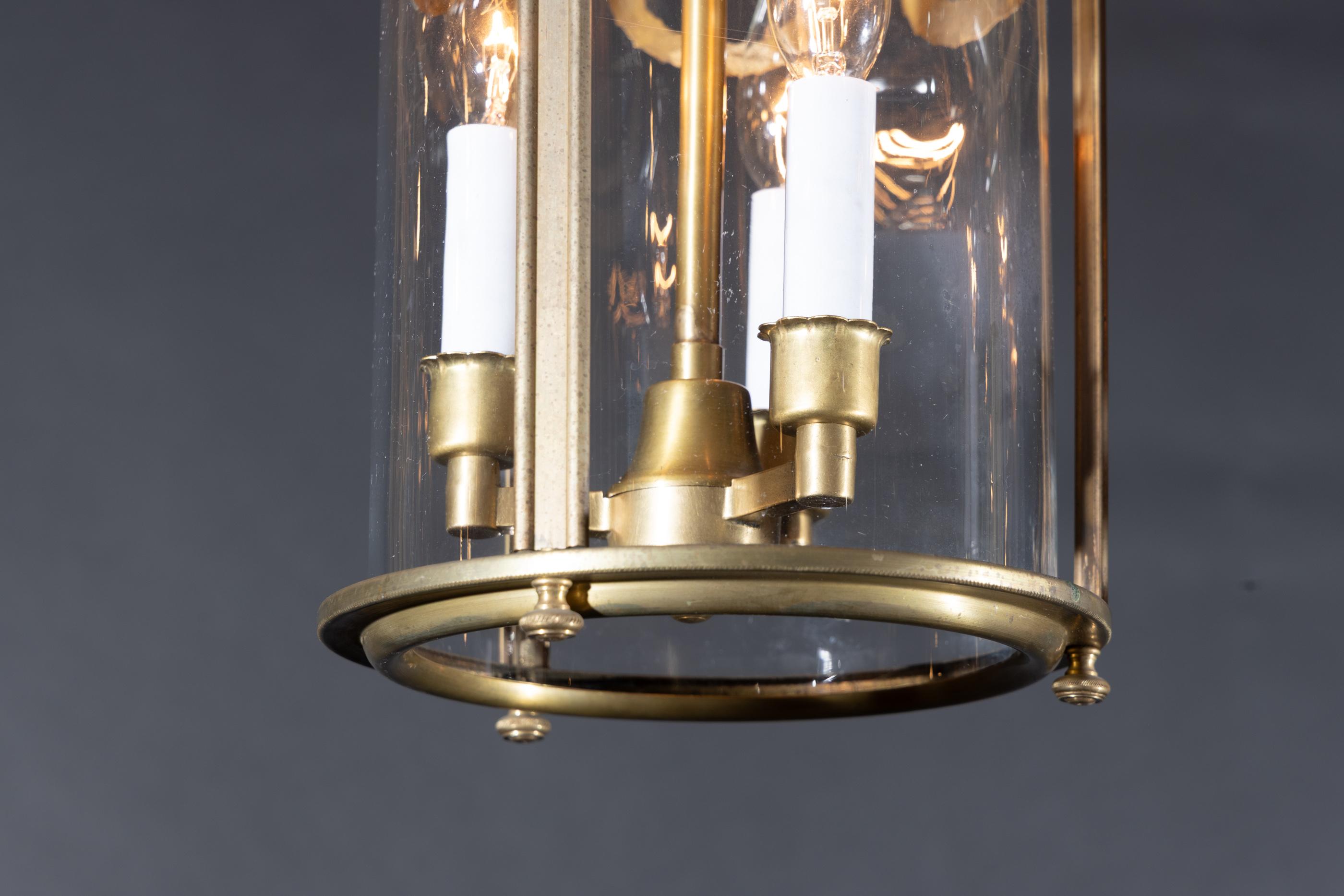 Ces lanternes cylindriques proviennent d'Italie et sont décorées de guirlandes qui pendent du bord métallique supérieur des lanternes. Un trio de feuilles de palmier se trouve sur le bord métallique, espacé par trois bras qui soutiennent la tige de