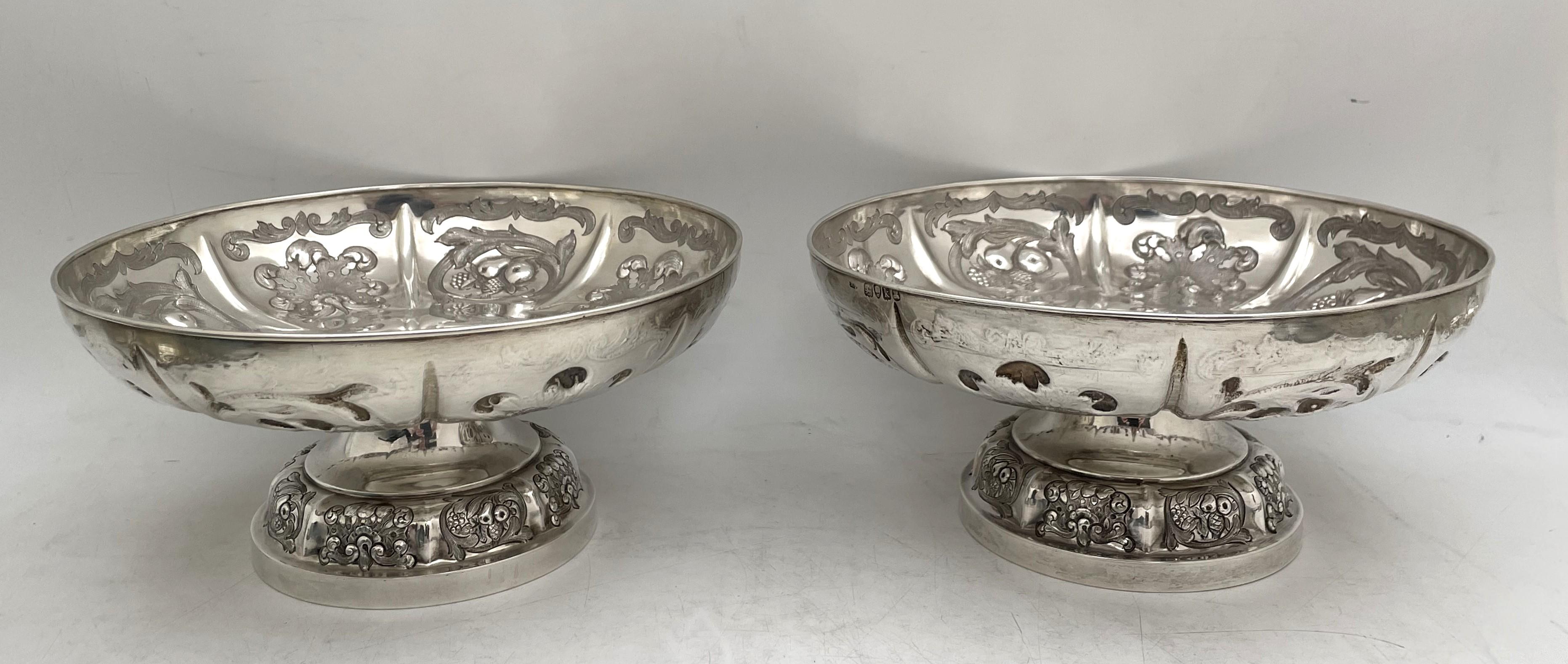 Pair of Garrard English sterling silver footed bowls or dishes, made in 1825 during the Georgian era, beautifully adorned with stylized geometric and natural motifs in relief. They measure 8'' in diameter by 3 7/8'' in height, weigh 39 troy ounces,