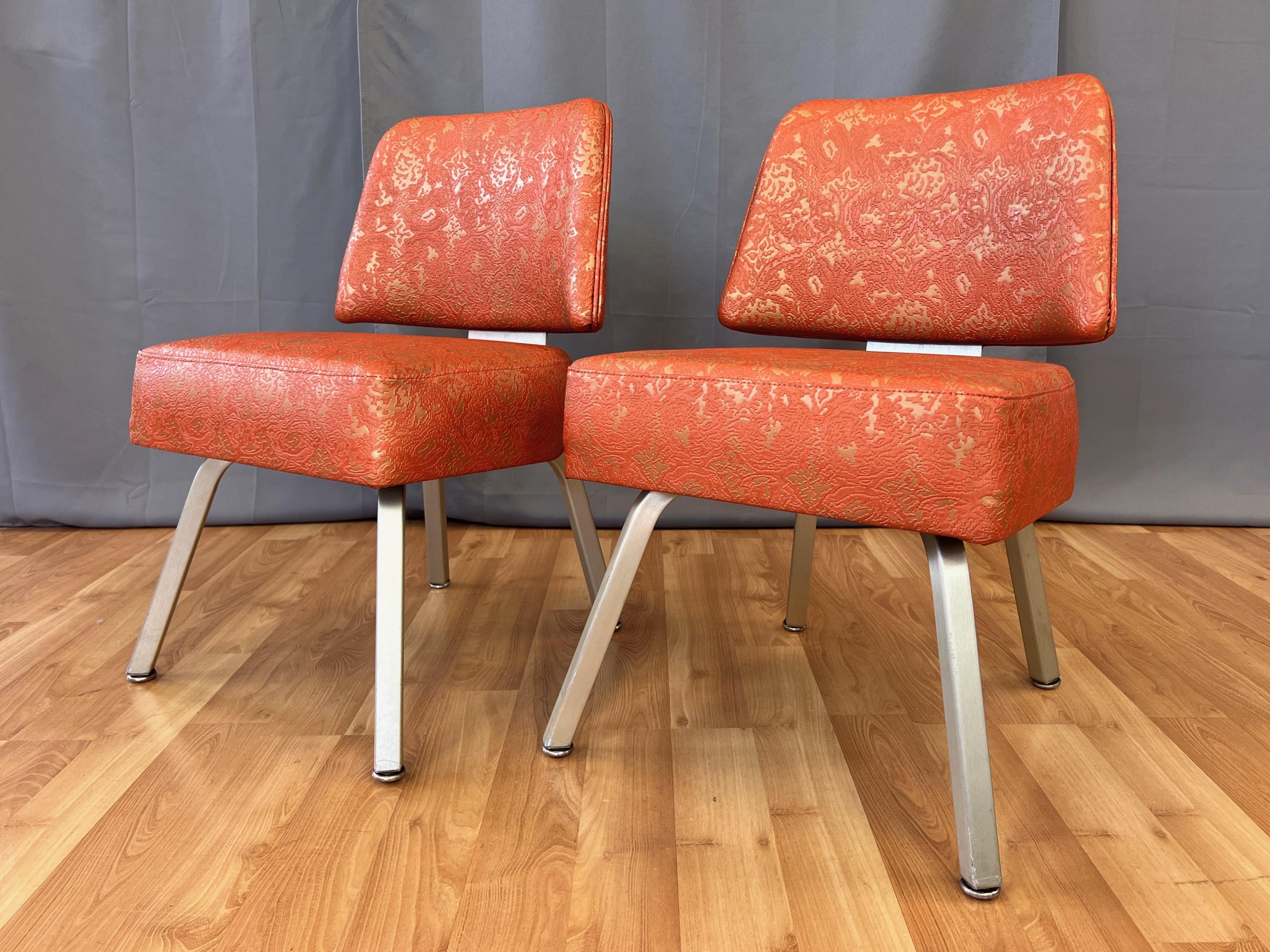 A fabulous pair of very uncommon circa 1960 orange & gold vinyl and brushed aluminum model L-90 side chairs by the Gasser Chair Co. from their “California Cocktail Lounge” line.

The epitome of classic American mid-century modern style, featuring
