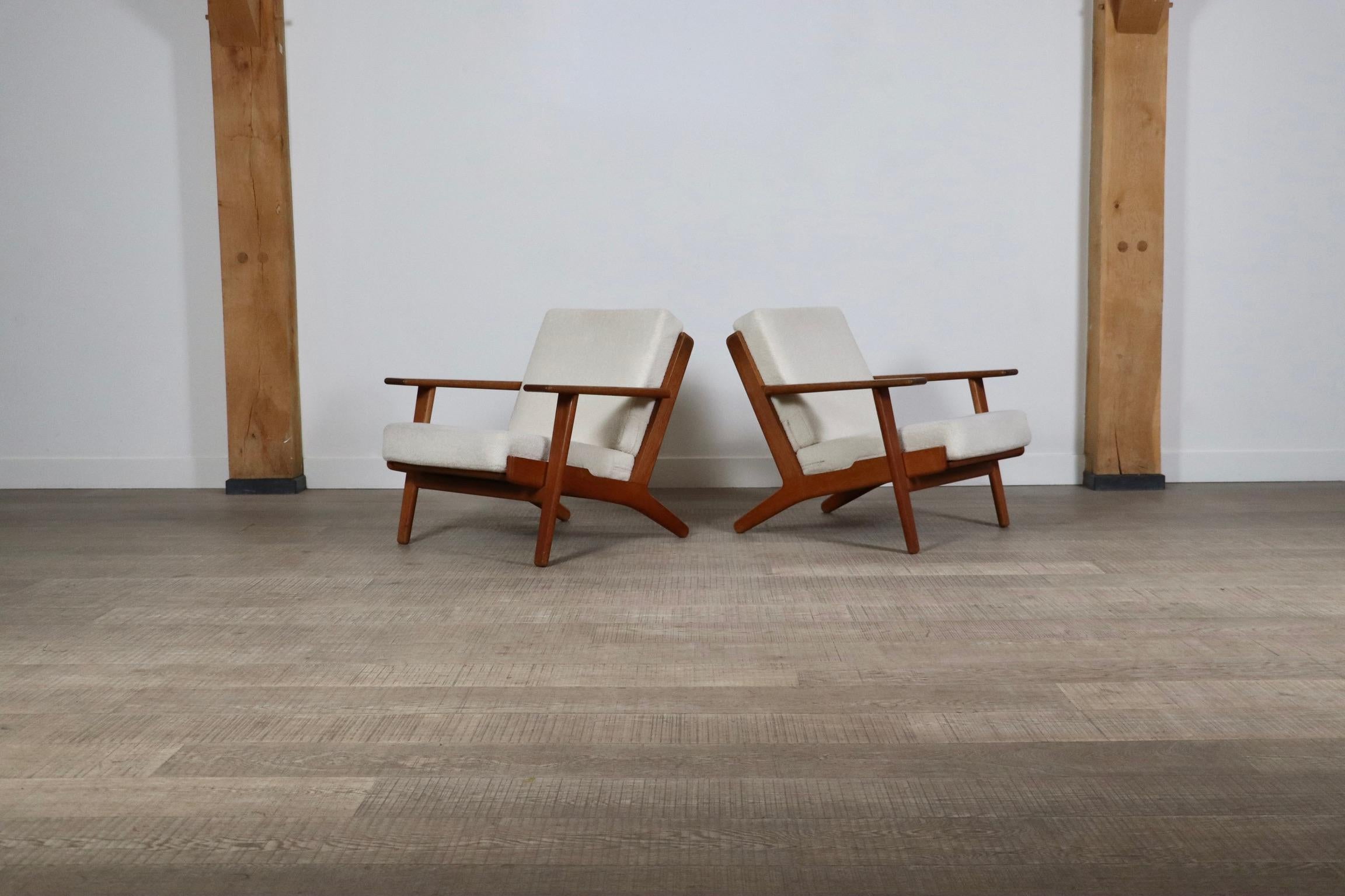Nice pair of GE290 armchairs by Hans Wegner for Getama, 1950s. Solid oak frame with original sprung cushions newly upholstered in a bouclé fabric to add to the comfort of the design. This model is also known as the “plank chair” referring to the
