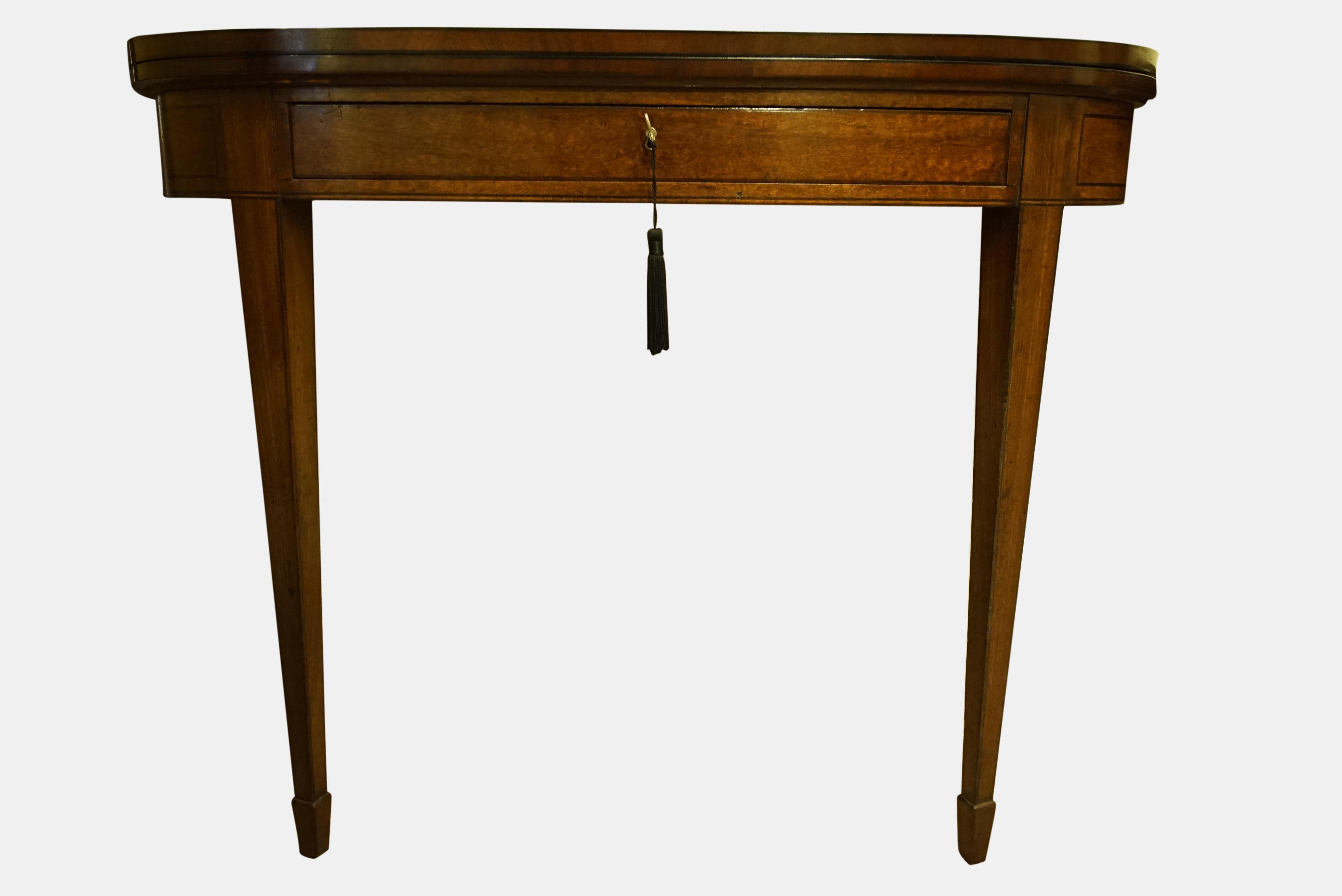 A good pair of George III D shape mahogany foldover card and tea tables, inlaid with ebony stringing, each with a locking drawer, raised on taper legs and splade feet,


circa 1795.