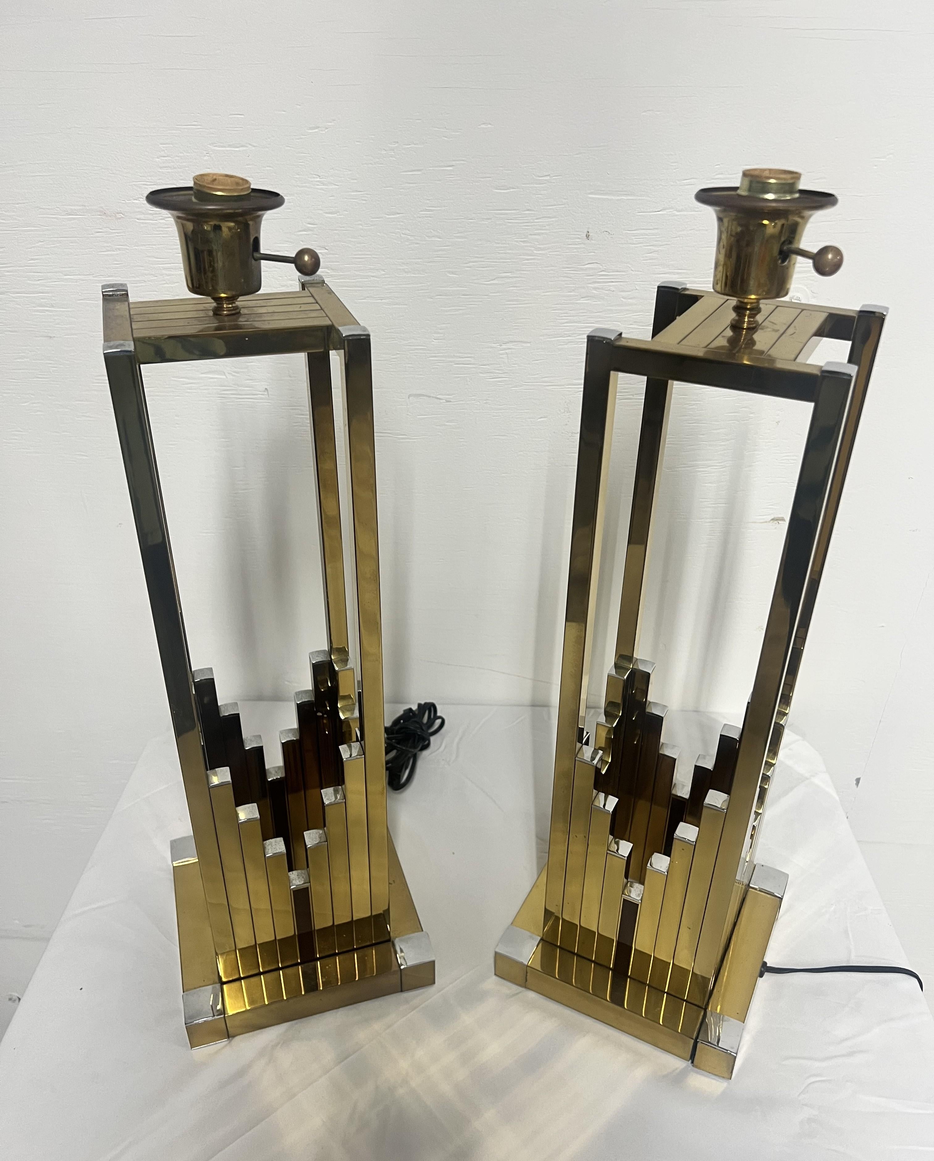 Pareja de lámparas de mesa geométricas de latón y cromo de Willy Rizzo para Lumica 

Estructura de tubo metálico de sección cuadrada con pátinas cromadas y doradas. Conserva el portalámparas original, de baquelita dorada, para tres bombillas con la