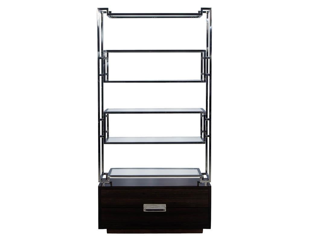 These American designed bookcases features geometric stainless steel frames that supports six floating glass shelves. The gorgeous Macassar Ebony base includes two drawers accented with stainless steel pulls. A modern yet timeless addition to any