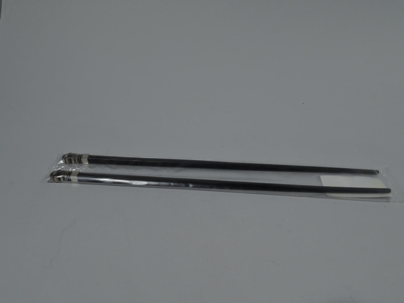 Pair of chopsticks in Acorn pattern. Made by Georg Jensen in Copenhagen. Tapering ebonized shaft with an acorn terminal. A modern and functional application of Johan Rohde’s classic motif. Postwar hallmark. In original sealed plastic bag and box
