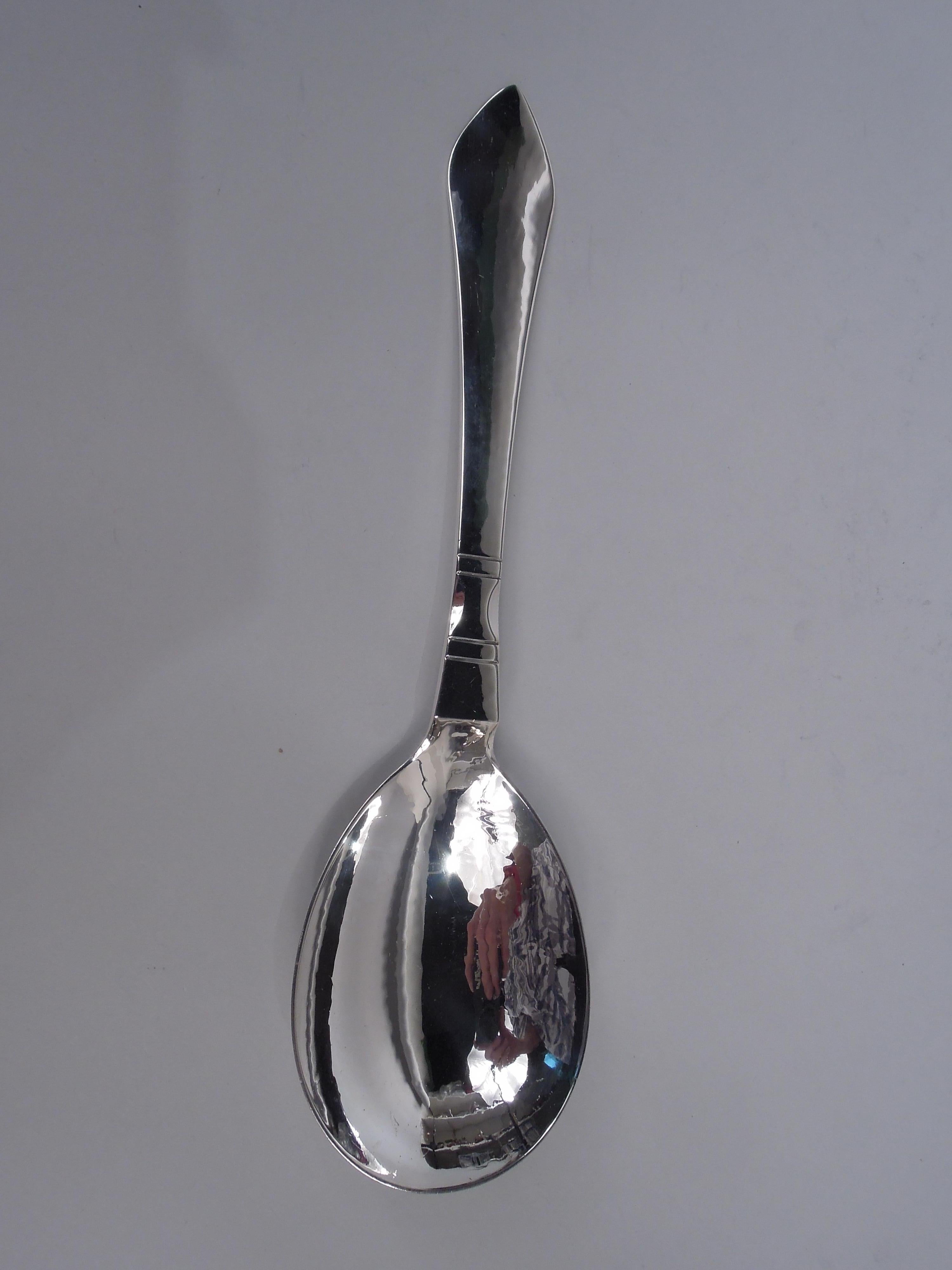 Pair of Continental sterling silver salad serving spoon and fork. Made by Georg Jensen in Copenhagen. Flat and tapering stems with pointed terminals and incised double-sided horizontal bands. Oval bowl and 4-tine shank. Designed by the master and