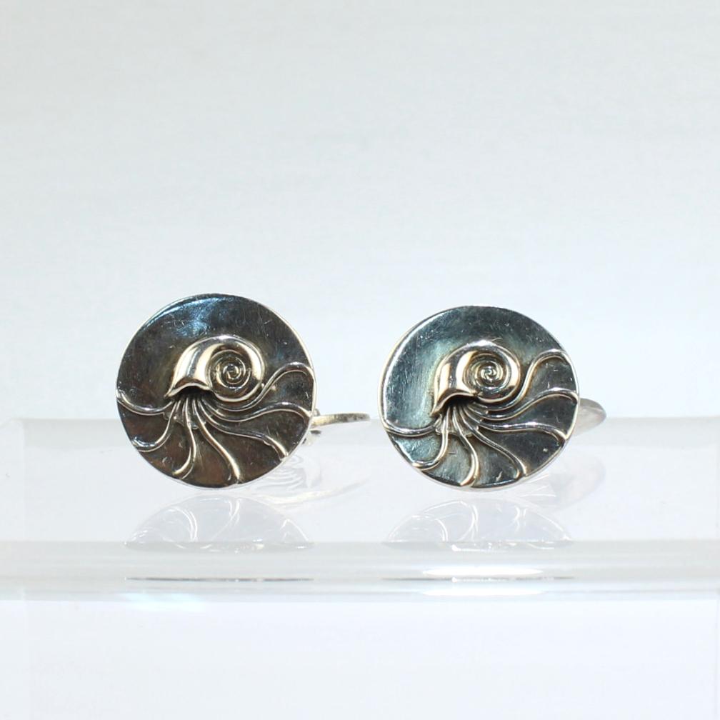 A fine pair of Georg Jensen cufflinks in sterling silver.

With a nautilus shell in relief to the front face.

Model No. 52.

Designed by Henry Pilstrup.

A great addition to any collection!

Date:
Mid-20th Century

Overall Condition:
They are in