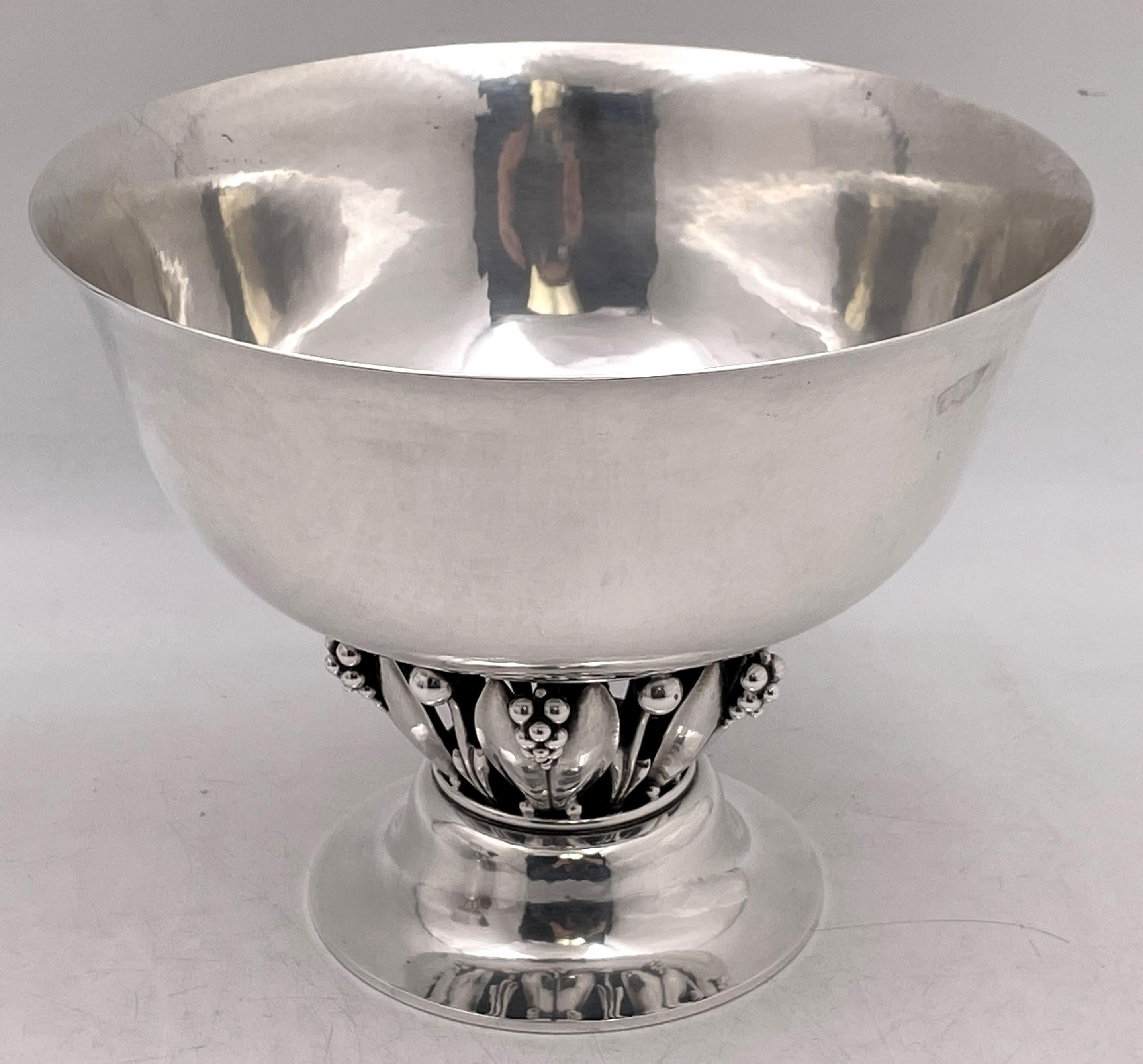 Pair of Georg Jensen sterling silver centerpiece bowls, in pattern number 197A, beautifully hand hammered, showcasing stylized natural motifs reminiscent of the Art Nouveau style, and standing on a stepped circular base, from the early to mid-20th