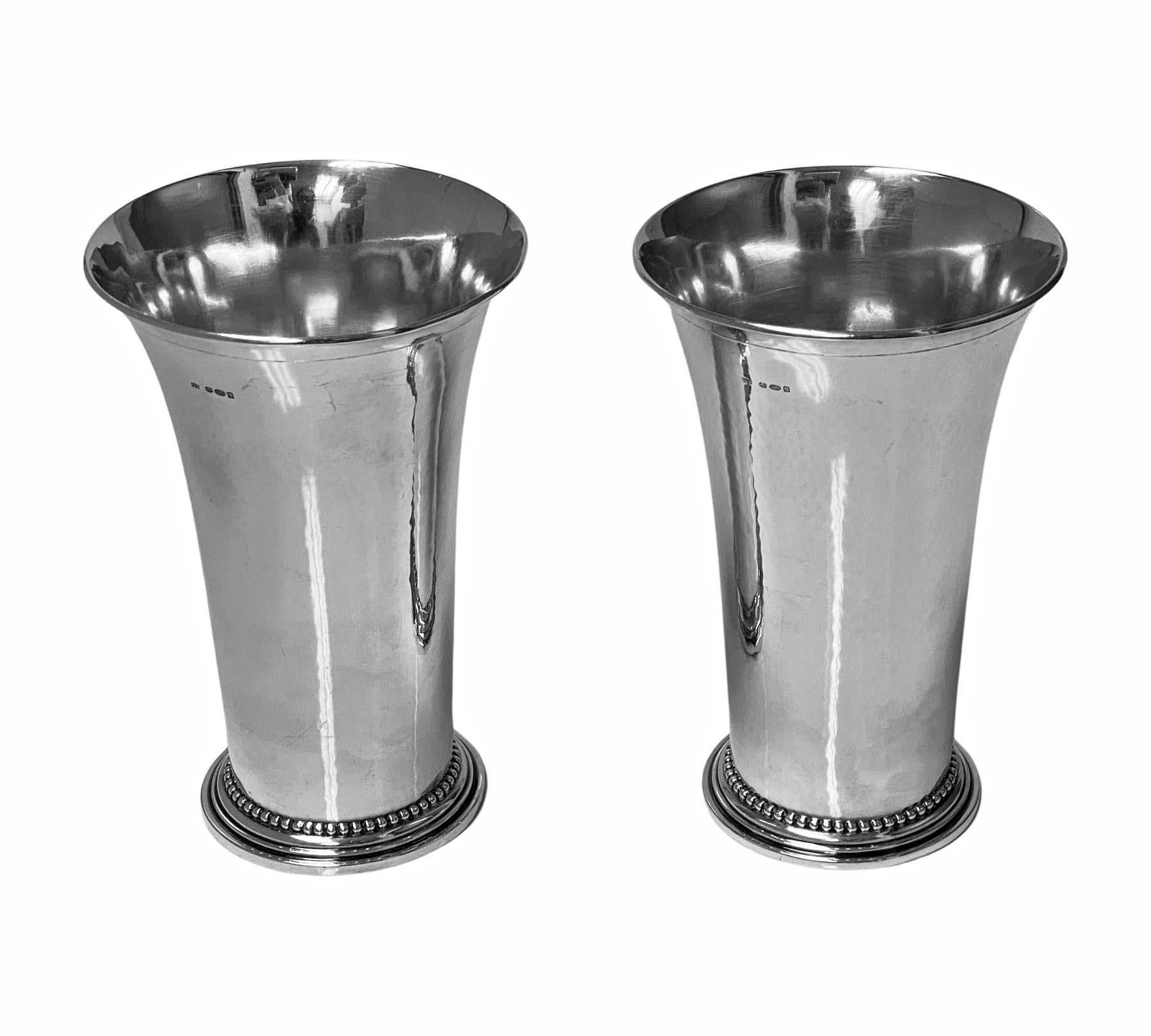 Pair of large Georg Jensen sterling vases. Each hand hammered tapered cylindrical form with flared everted rims on circular and concentric bead design bases. Stamped on base with Jensen marks for 1925-1932 numbered 107Band import marks for London