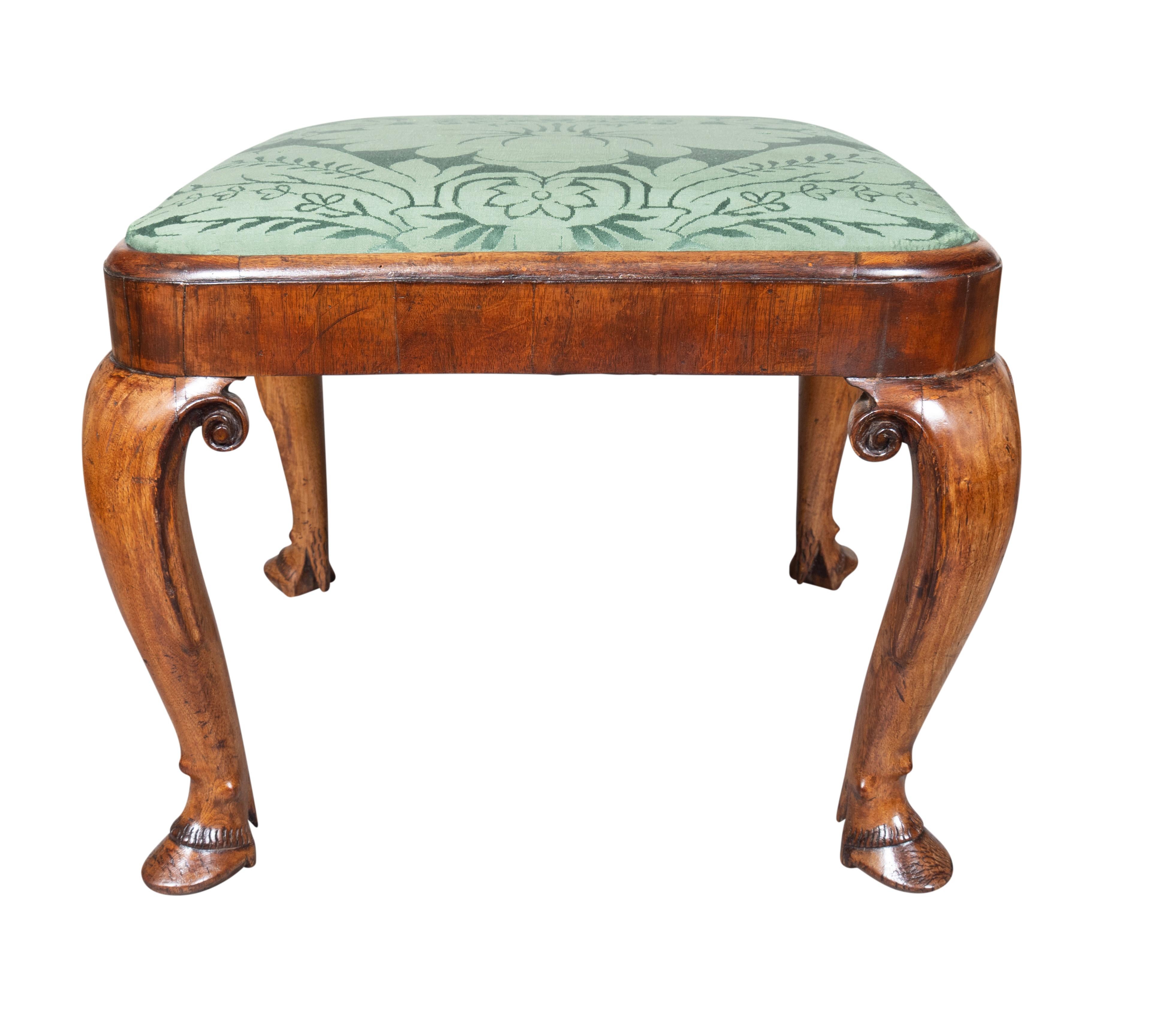 Each with rectangular drop in green damask upholstered seat and molded edge of seat frame. Cabriole legs with carved scrolls and ending on hoof feet. By repute purchased from Mallett, London.