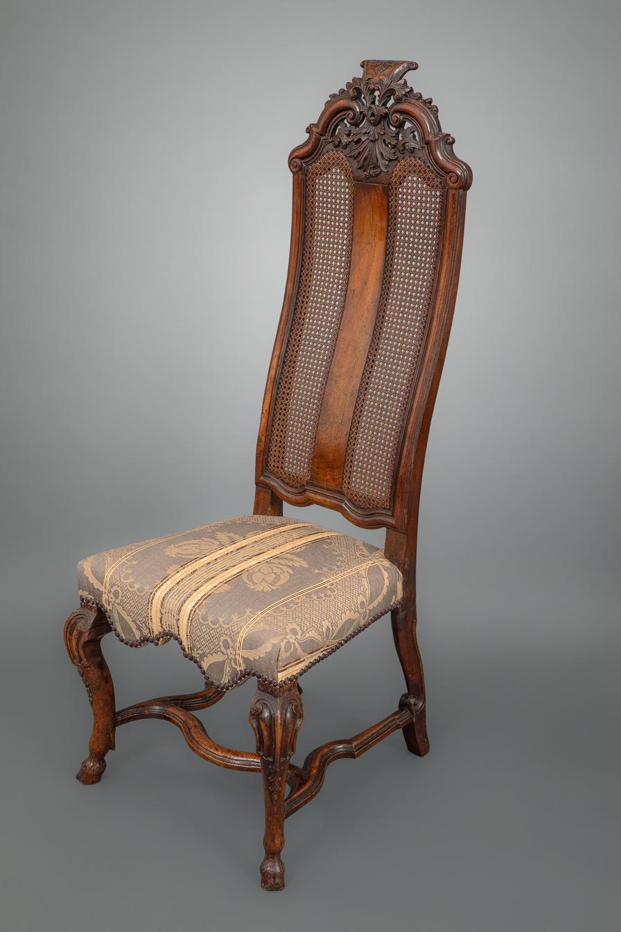 A very fine quality and elegant pair of side chairs, each with foliate and scroll-carved pierced cresting above a curved backrest and splat with original caning over an over upholstered seat with shaped apron raised on channel-carved cabriole legs