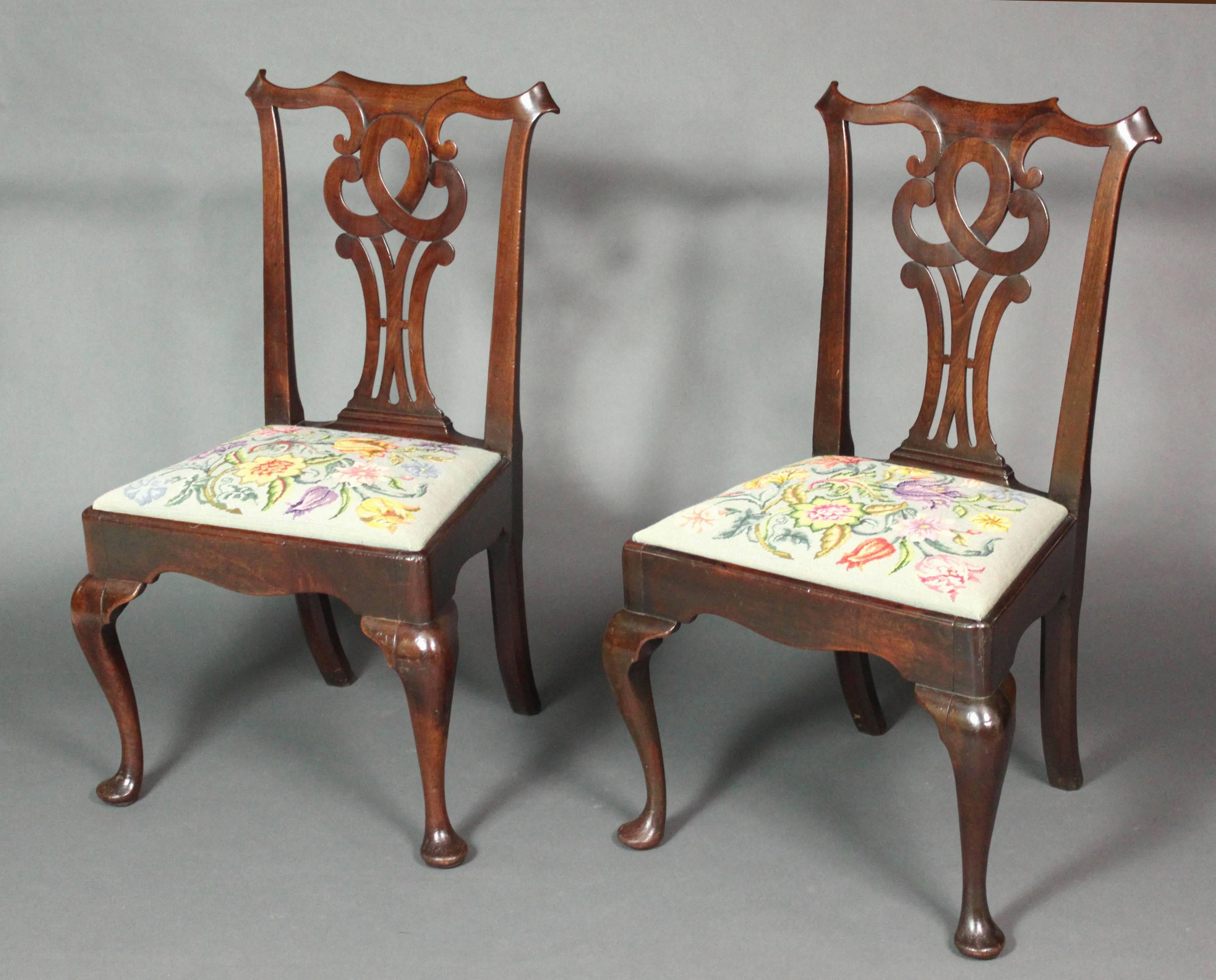 A pair of George II cabriole leg chairs in mahogany of a good color and patina; attractive pierced splats and shaped front seat rails.
Hand-stitched modern needlework seats. One old crack in a back leg, but structurally sound; otherwise in good
