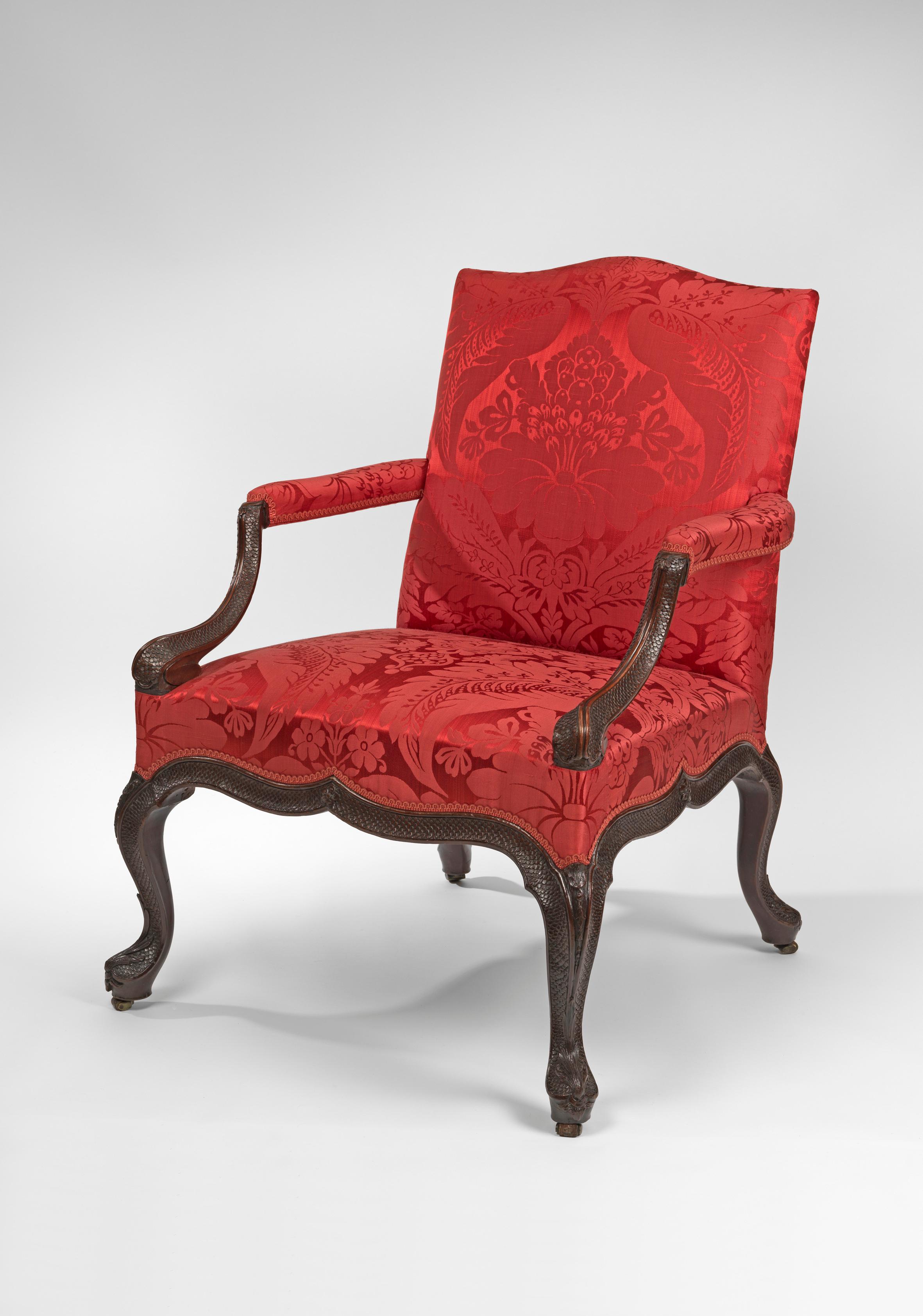 Attributed to William and John Gordon 

Each with shaped padded back, arms and seat, covered in red silk damask, with outswept dolphin-scale carved arms headed by half-flower heads, on a scrolling, scale carved frame centred by flowerheads, on