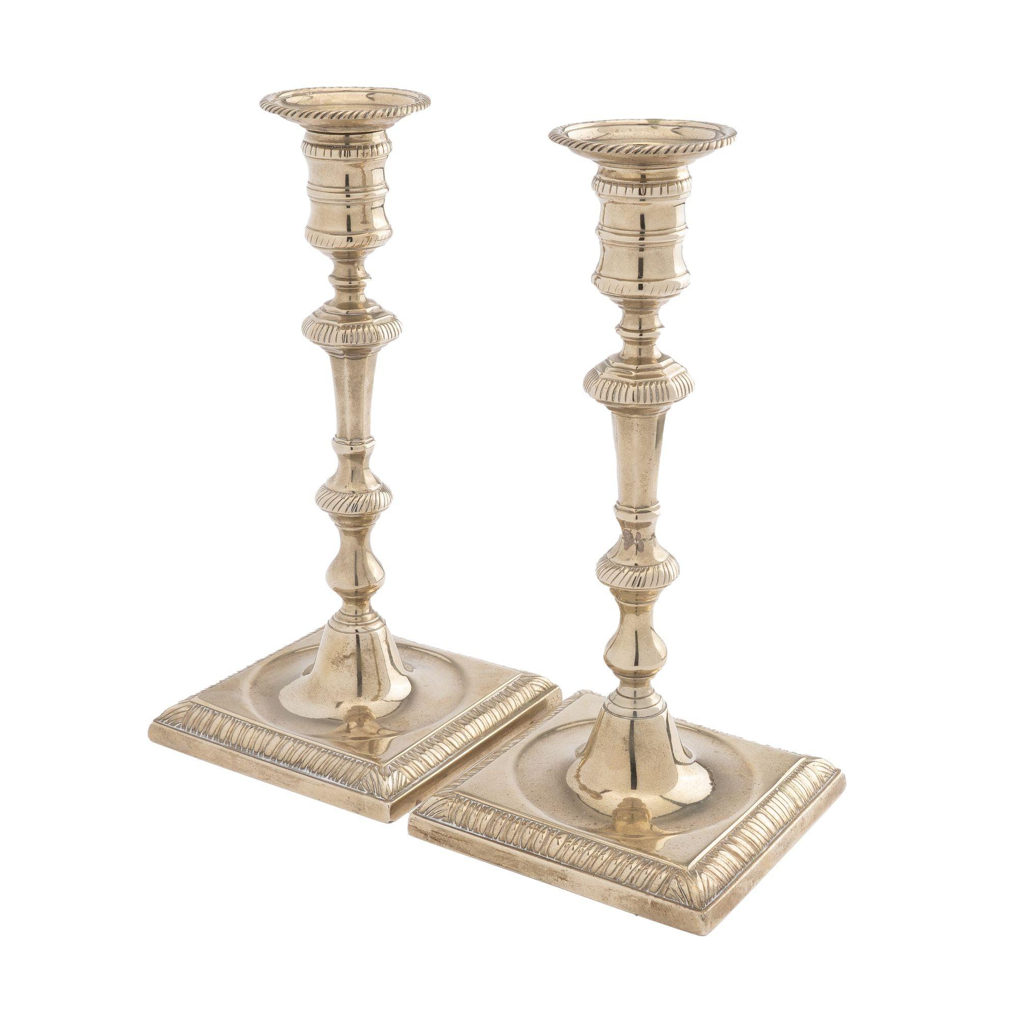 Pair of silver form George ll cast paktong candlesticks. The candle shaft rests on square base and fitted with a gadroon edged circular bobesh.
Birmingham, England, circa 1750-60.