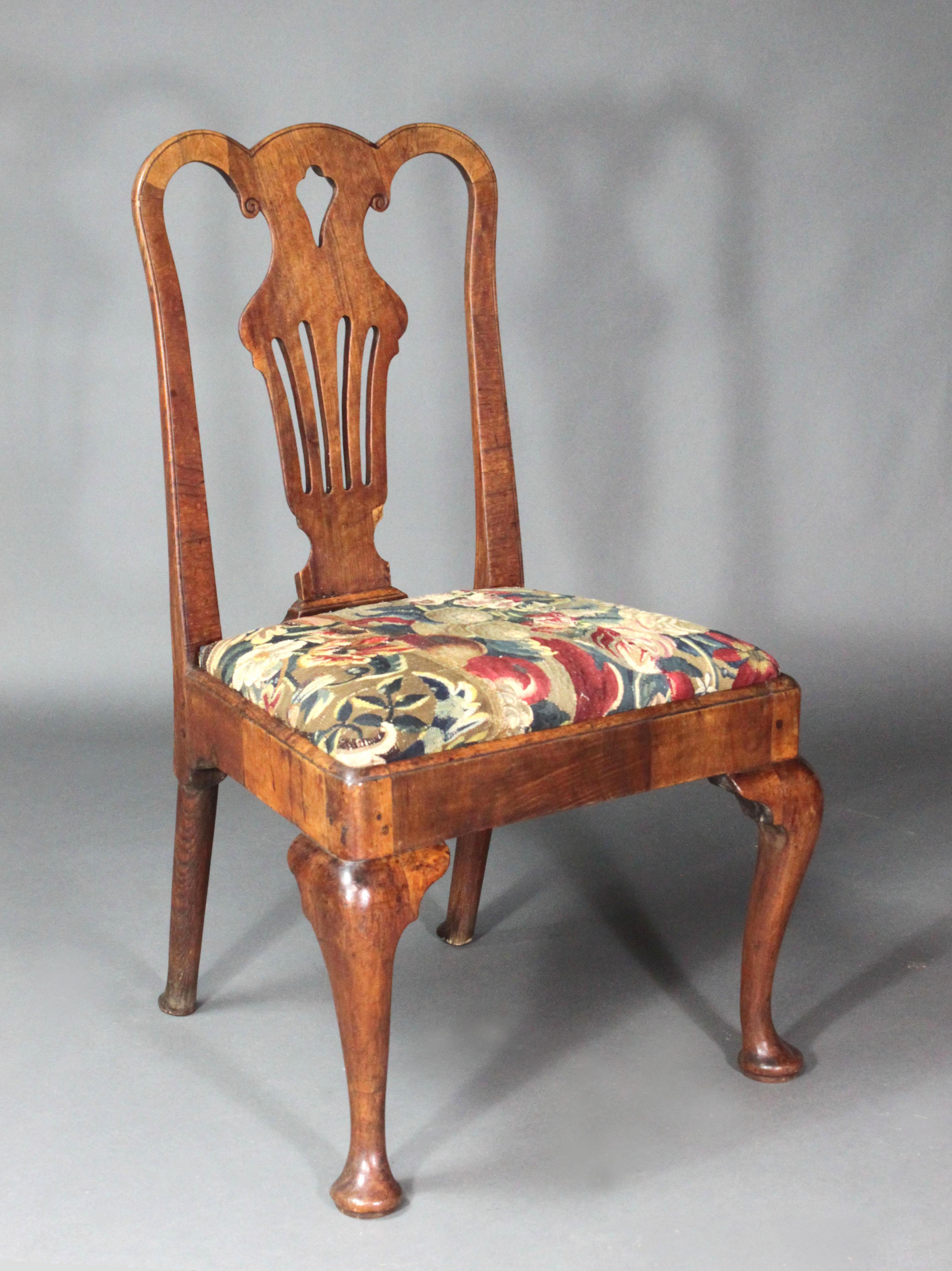 A pair of George II veneered walnut chairs of an original colour and patina. Good bold cabriole legs & generous depth, pierced back splats; the seats covered in fragments of 18th Century tapestry; the back legs in ash.
For comparison, see Adam