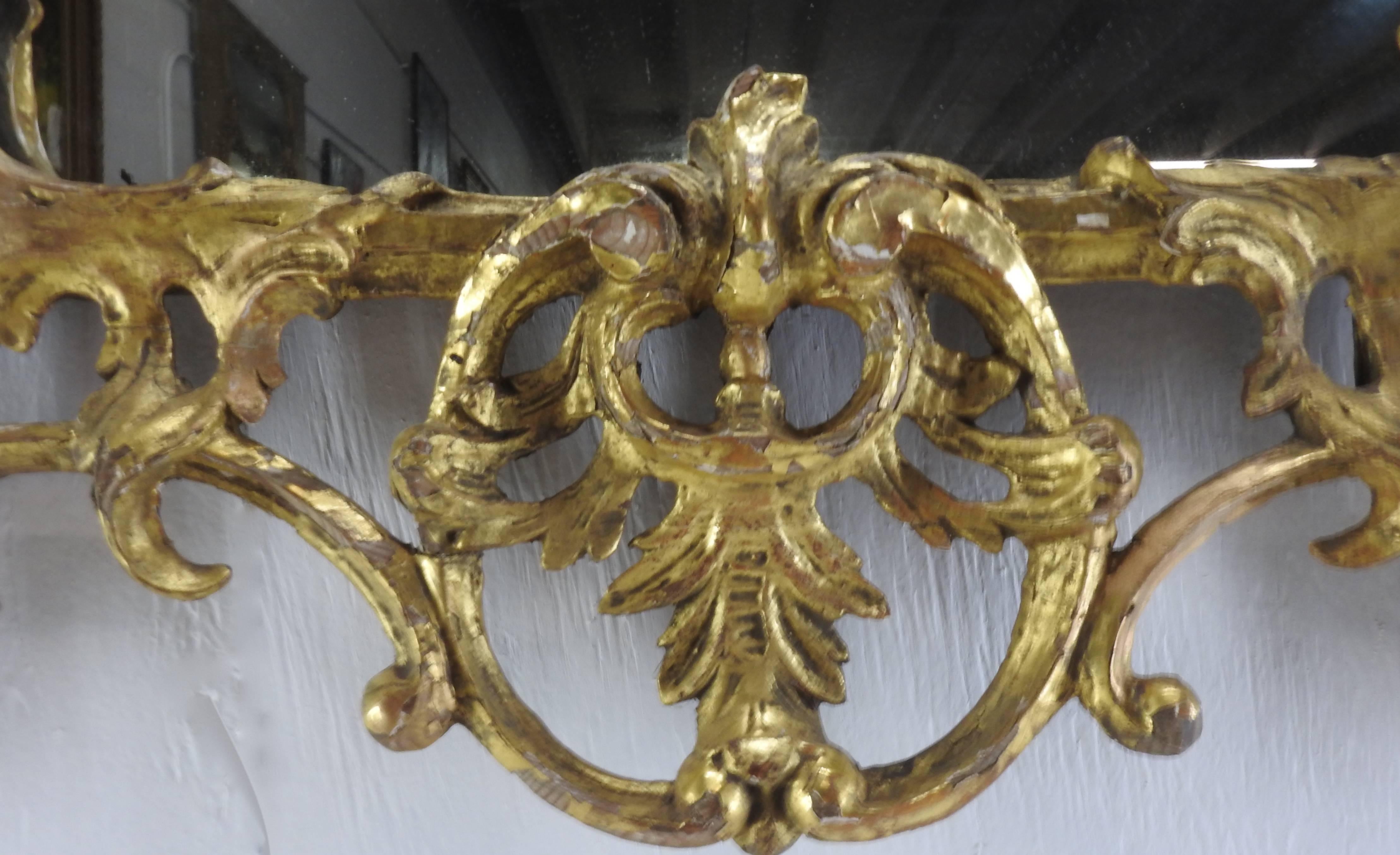 We are featuring an elaborate pair of George III bright gilt mirrors. Beautiful vines intertwine and connect to the scrollwork that for these beautiful mirrors. They do have the original mirrors and backing.