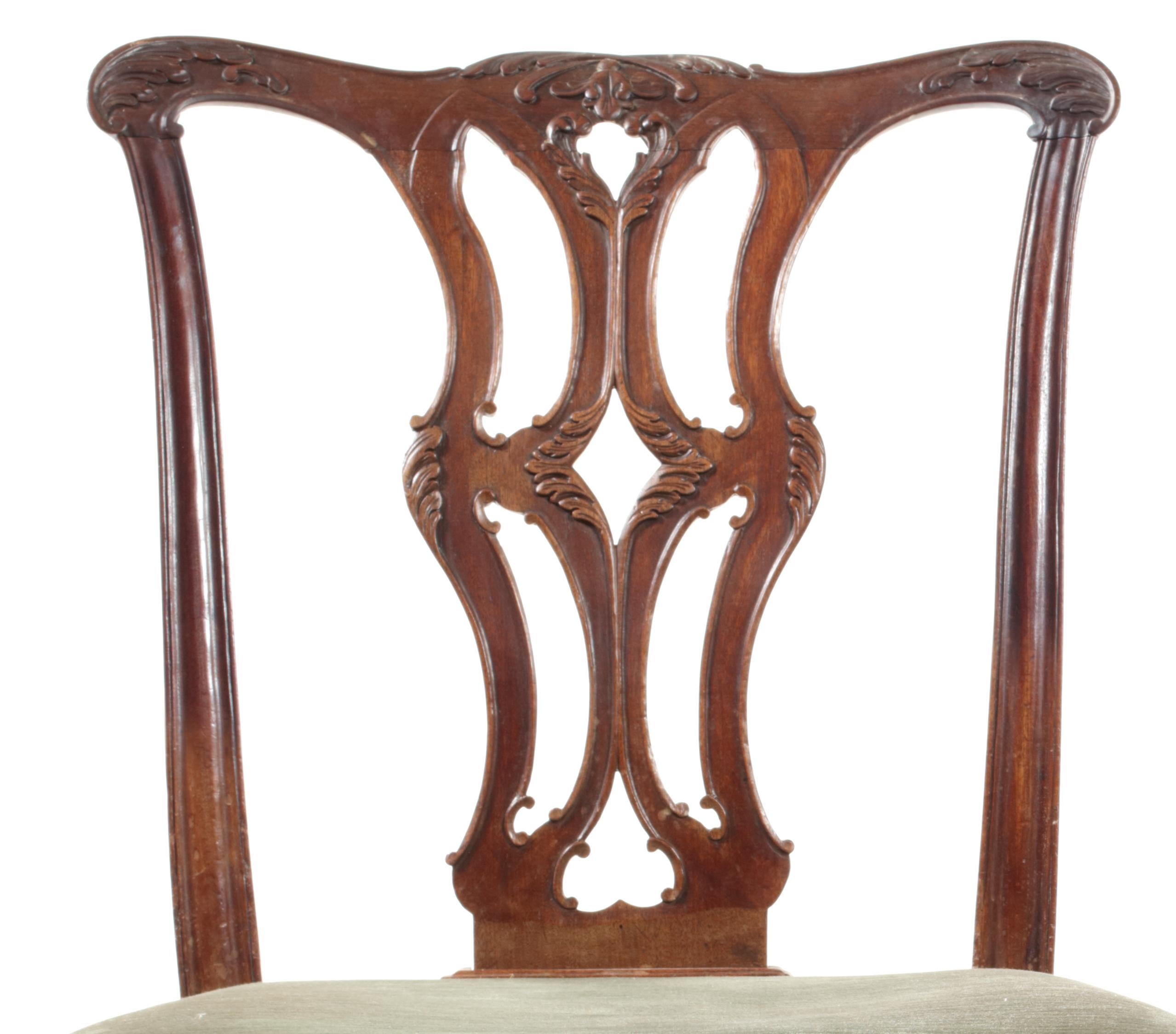 A pair of George III carved mahogany dining chairs in the Chippendale Gothic taste
The serpentine acanthus and bellflower carved top-rails above pierced splat above serpentine padded seats on square moulded legs with leaf carved brackets and 'H'