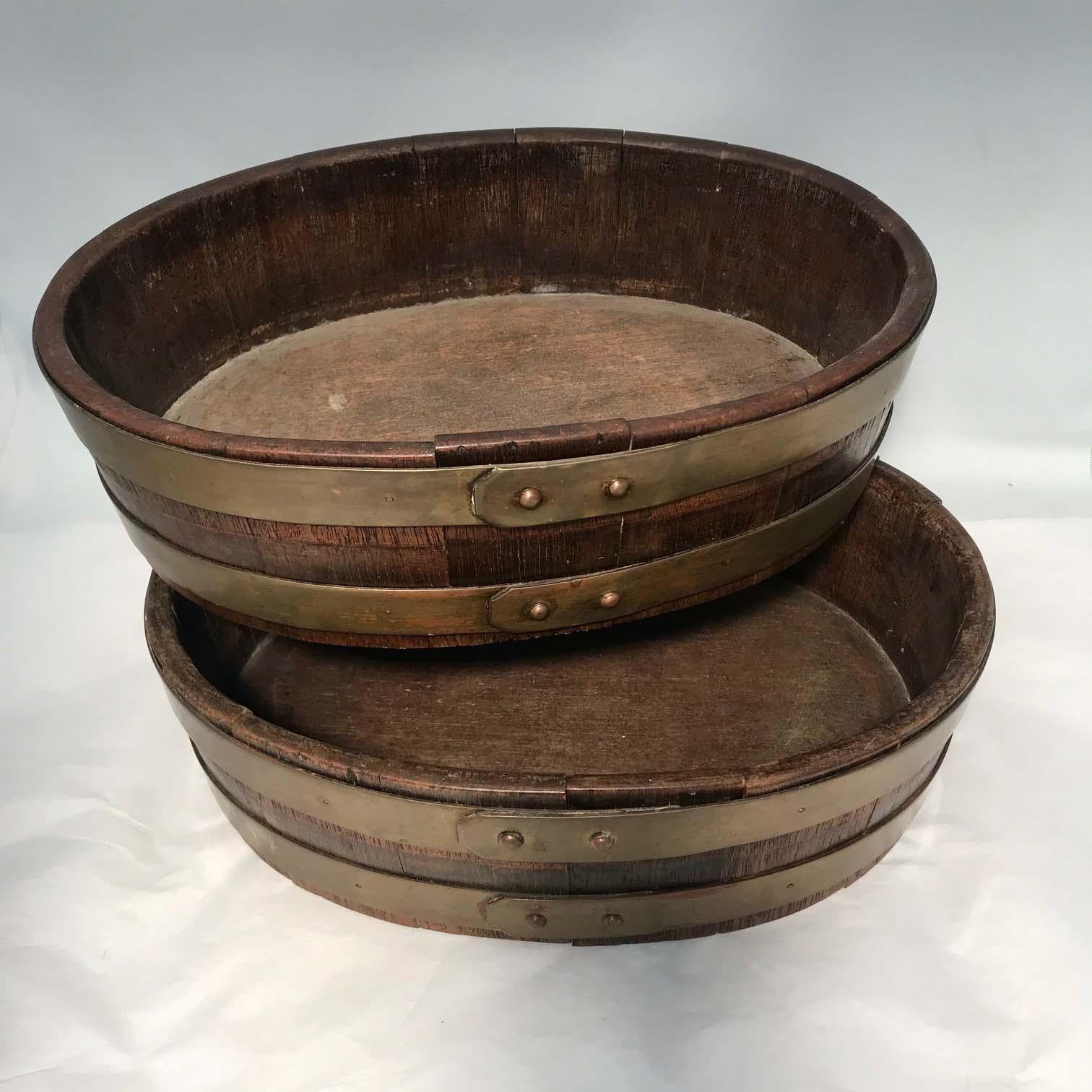 These are rarely found as a pair and are typically more bucket-shaped. This pair are shallow, oval, staved and brass-banded, they are ideal for anything served on ice since they are complete with galvanized liners. They could also be used for
