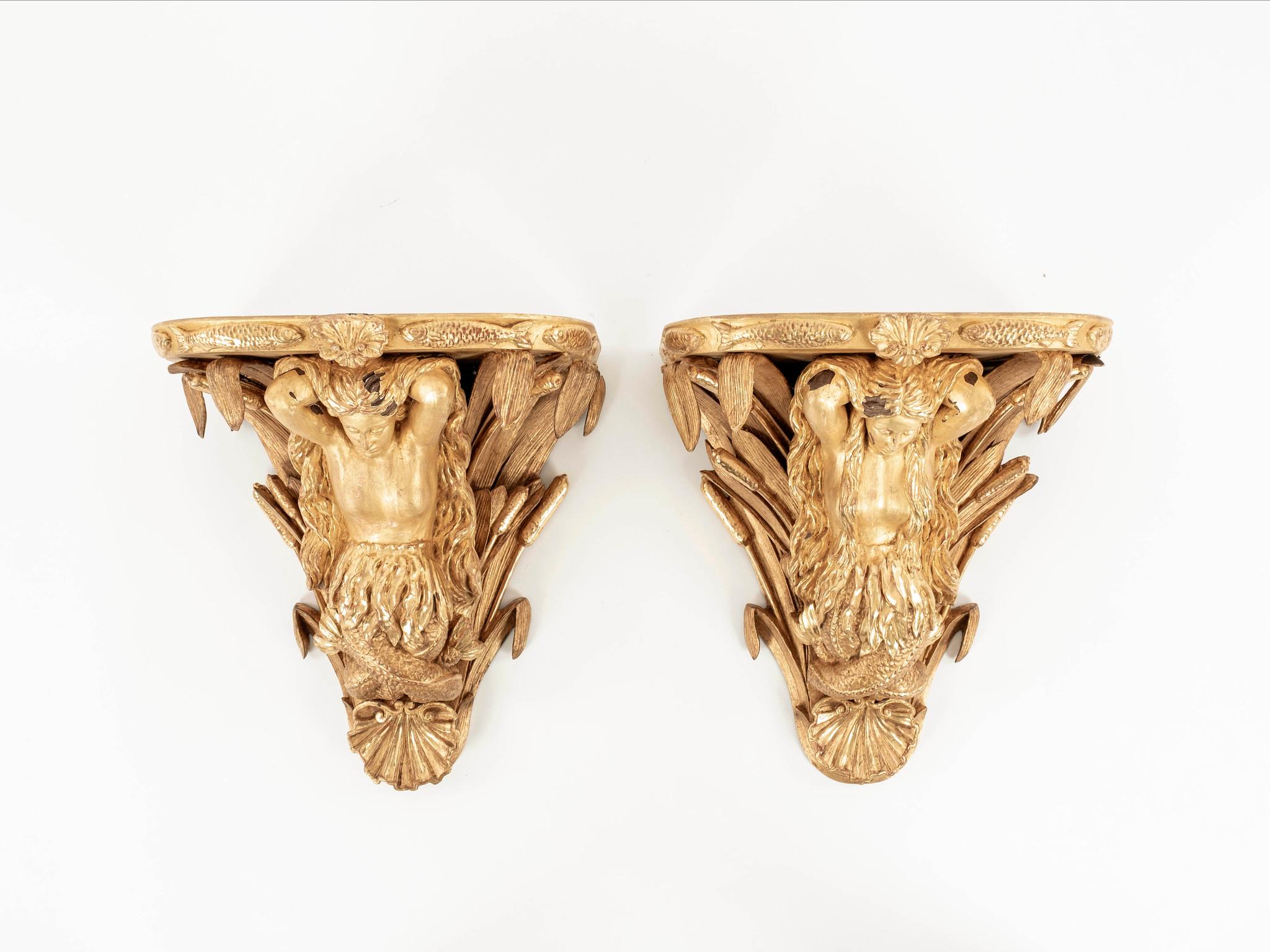 An exceptional detailed pair of mid-18th century George III giltwood wall shelves featuring mermaids with long flowing hair, spikes of cattails, shell cartouches and fish border along edge.
 