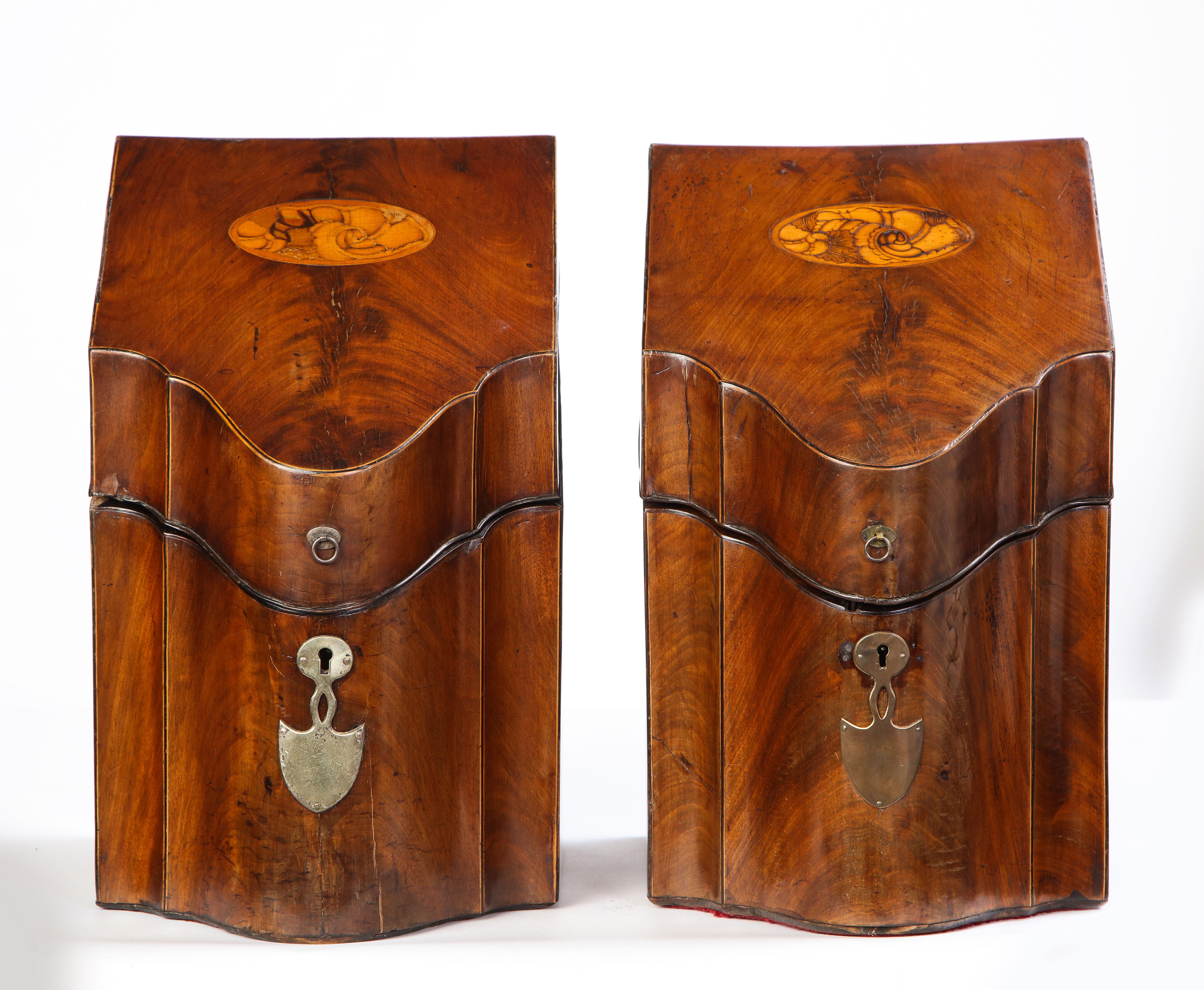 Pair of George III inlaid satinwood cutlery boxes, late 18th century. Each with a sloping serpentine-front hinged top inlaid with a decorative shell design, metal escutcheon plates, and enclosing a fitted interior.

Some of the most celebrated