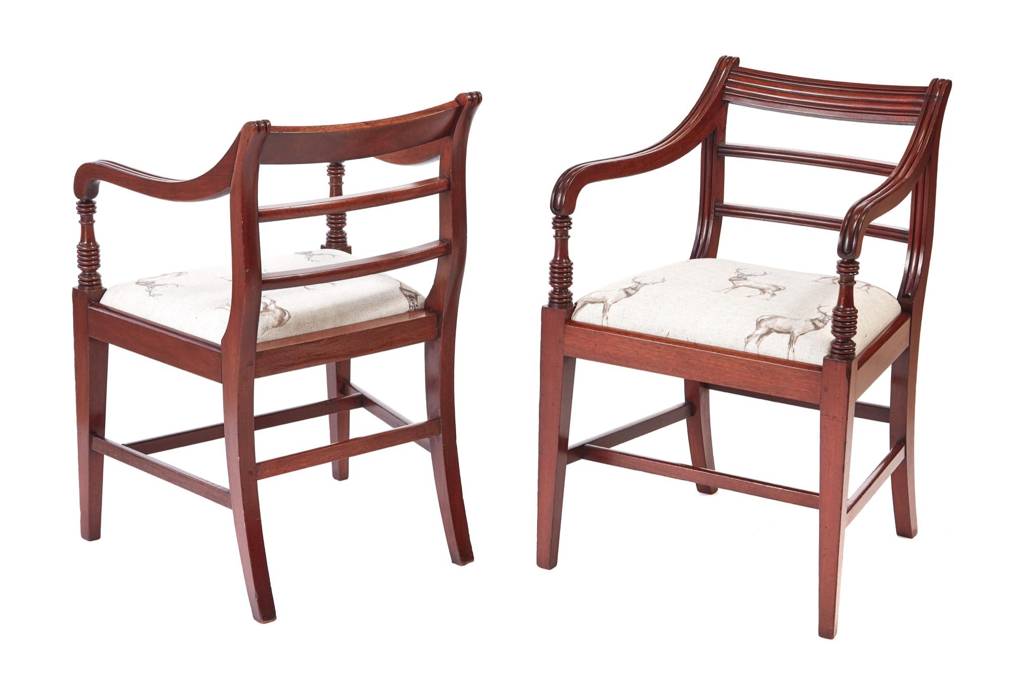 Fine pair of George III mahogany elbow/desk chairs with a shaped reeded top rail, two reeded centre splats, lovely shaped reeded arms with turned supports, drop in seats. It stands on square tapering legs to the front outswept back legs united by