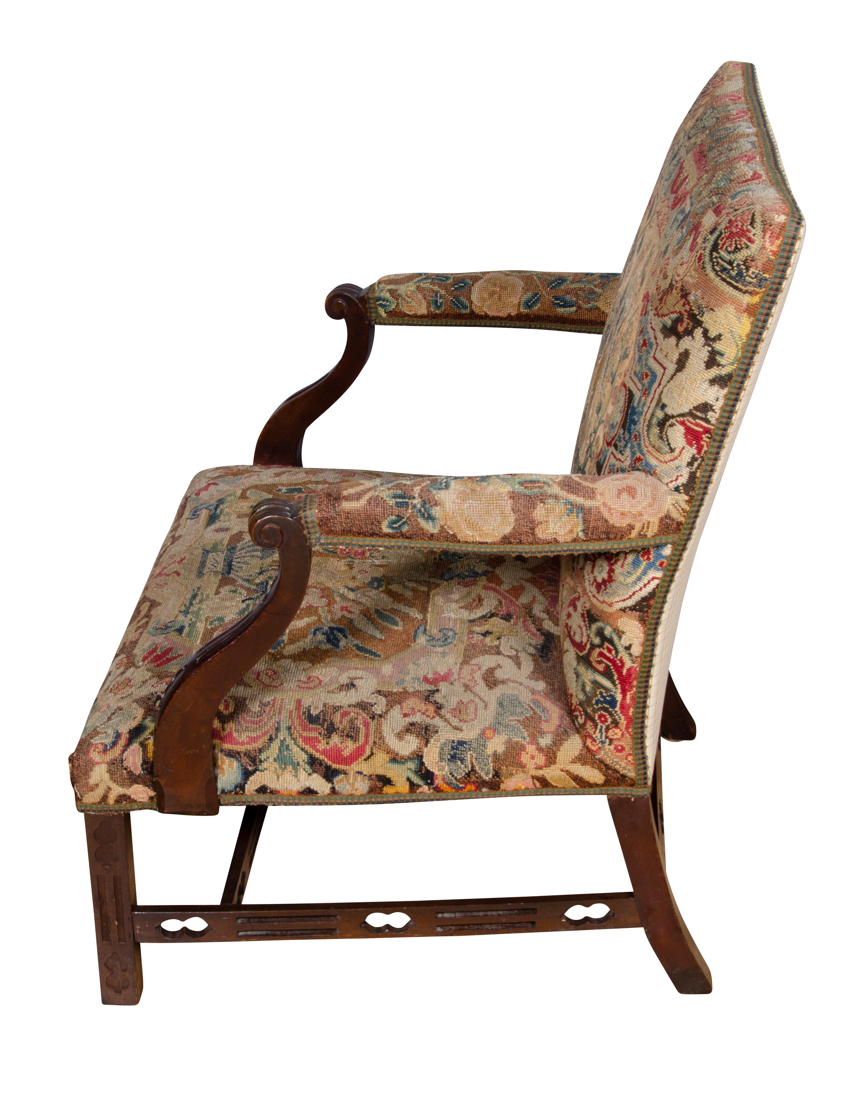 Each with square backs and seats upholstered in needlepoint with down swept arms, raised on square tapered legs joined by H form pierced stretchers.