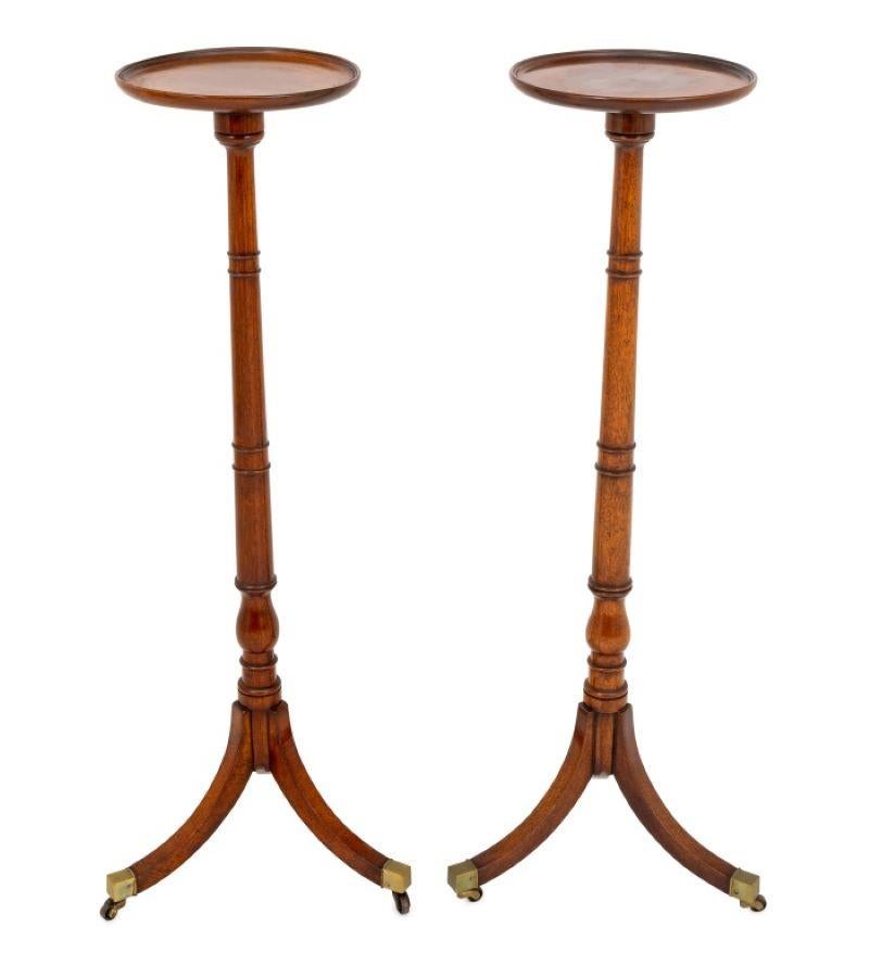 Paire de torchères en acajou George III, chacune reposant sur trois pieds évasés avec des capuchons en laiton se terminant par des roulettes. 42