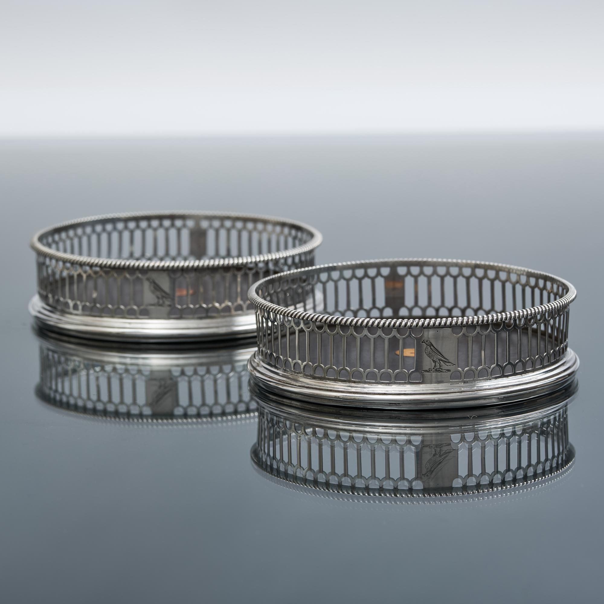 Paar durchbrochene silberne Weinflaschen- oder Dekanter-Untersetzer aus der Mitte des 18. Jahrhunderts mit ihren ursprünglichen Holzsockeln und zentralen dekorativen Knöpfen aus Knochen. Die Seiten sind mit einem Band aus geometrischen Mustern