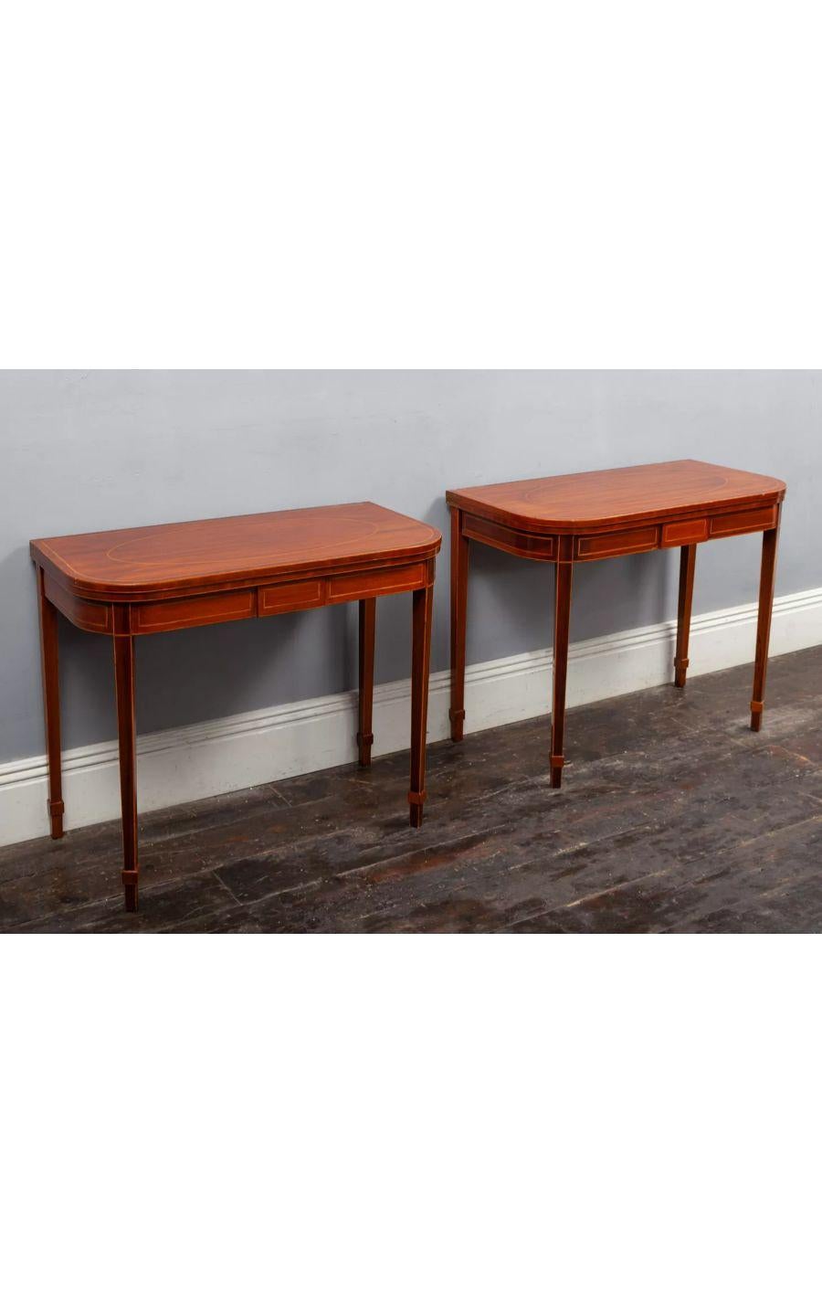 A pair of George III Sheraton period inlaid mahogany tea tables.

The tables are made from richly coloured mahogany with fine inlaid boxwood stringing.

The ‘D’ shaped hinged tops rest on twin gate supports with square tapering legs.

A great