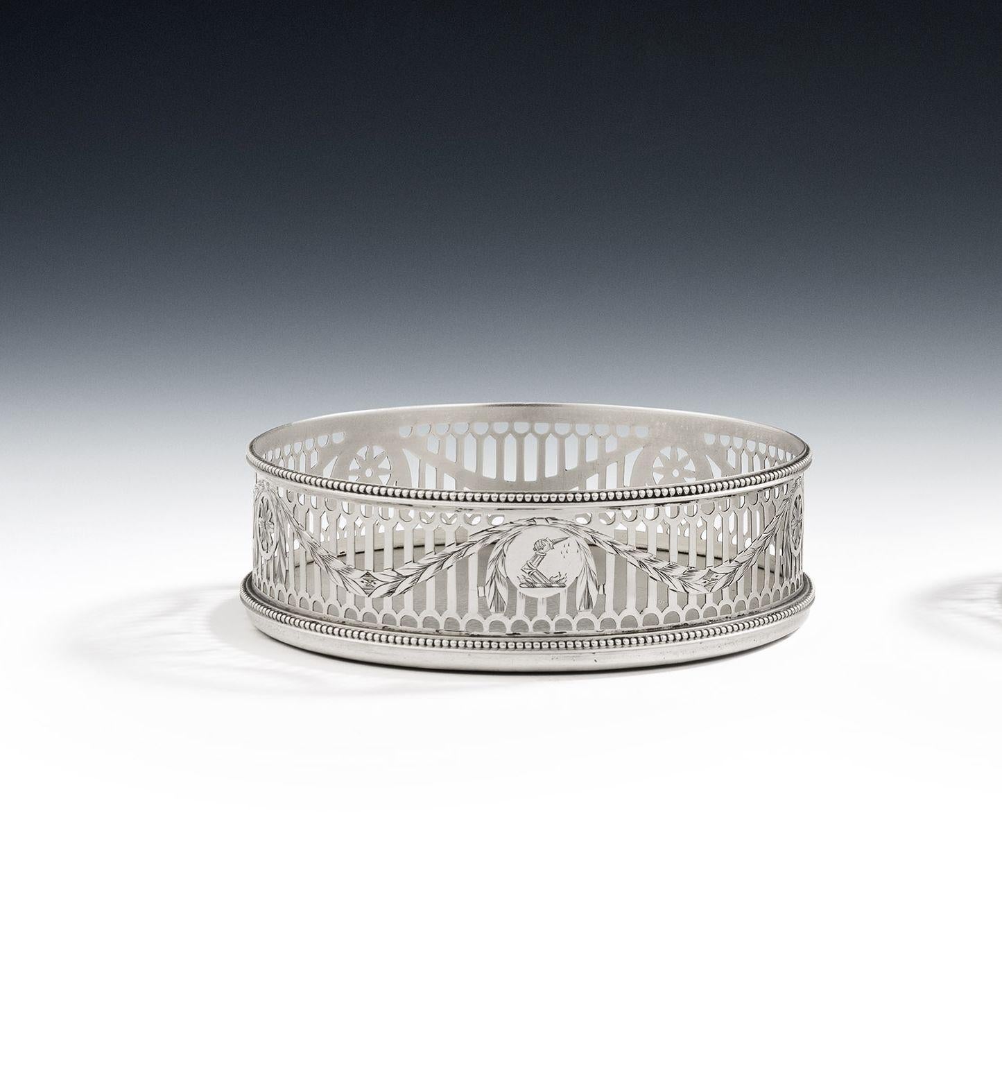 A very fine pair of george iii silver based wine coasters made in London in 1776 by william plummer.

The Wine Coasters are circular in form with a beaded base and rim.  The sides are finely pierced with Neo Gothic pails, as well as Classical laurel