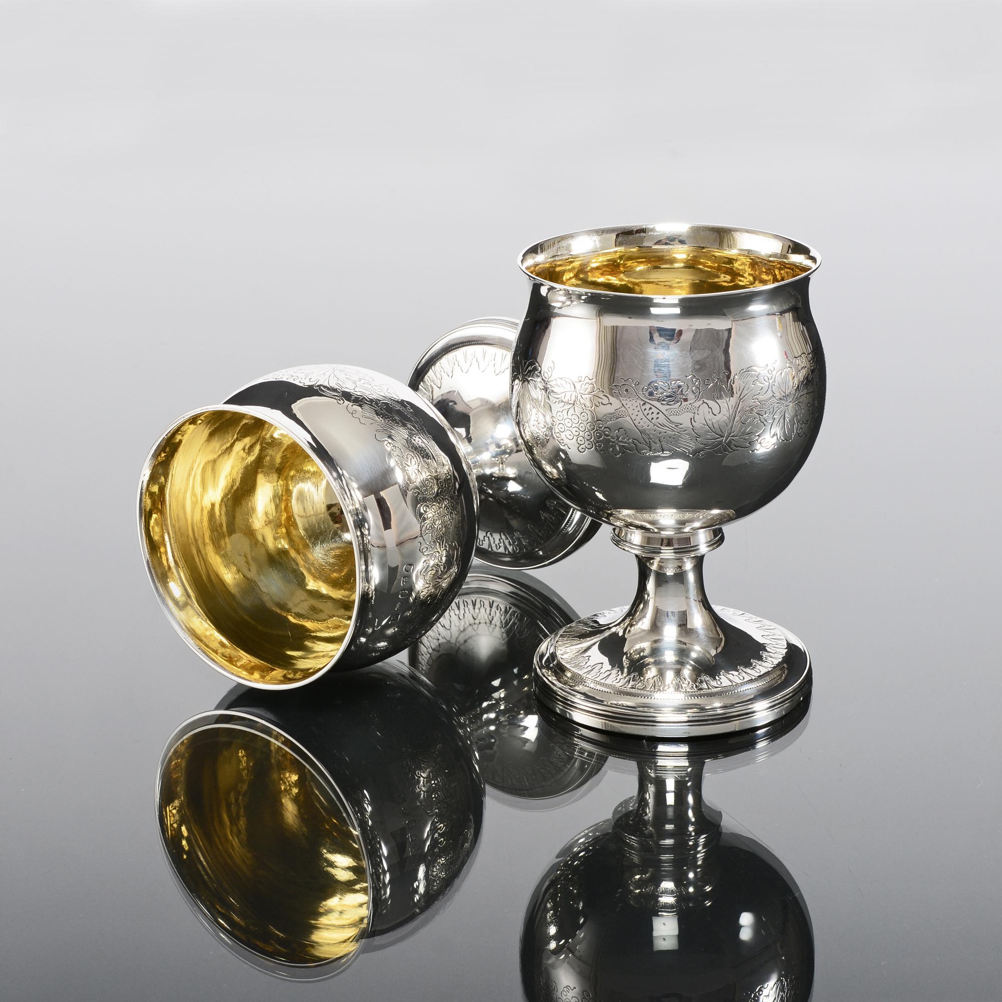 Pair of Georgian silver goblets, made in the reign of George III in 1814, with bulbous flared-lip bowls and round, tapering stems. The bodies are attractively engraved with stippled engraving which is typical of the period, depicting exotic birds