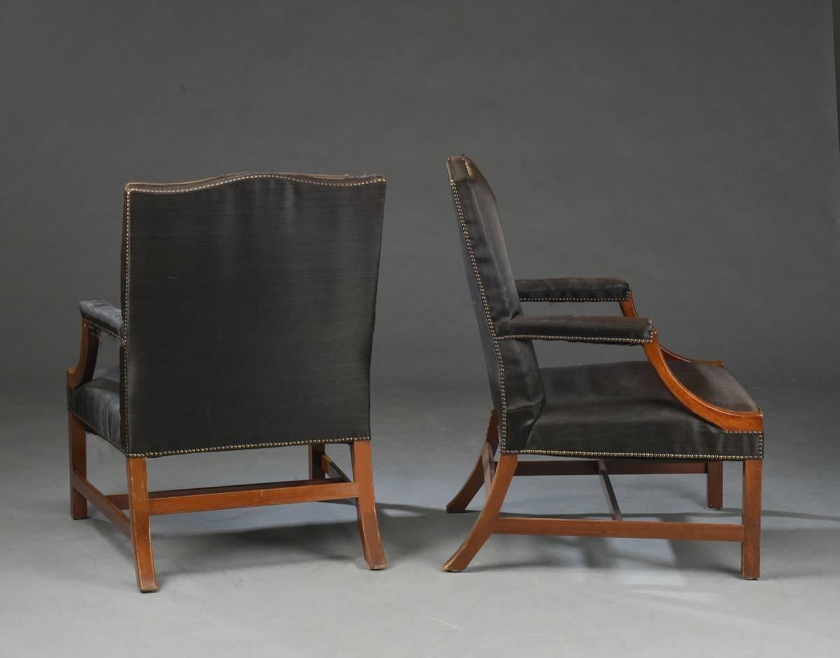 Pair of George III style mahogany armchairs, early 20th century. The chairs upholstered in close-nailed horsehair. Horse hair upholstery is in good usable condition, but some of the secondary upholstery is torn and some piping is loose, the wear to