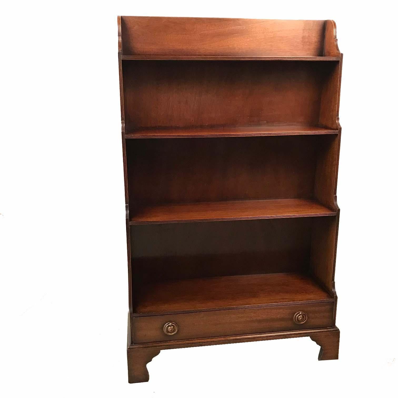 As the photos show, these bookcases are a faithful copy of the original type, complete with drawer, with brass ring pulls and raised on bracket feet. This pair is very versatile and useful not only in a library. They would ship easily.