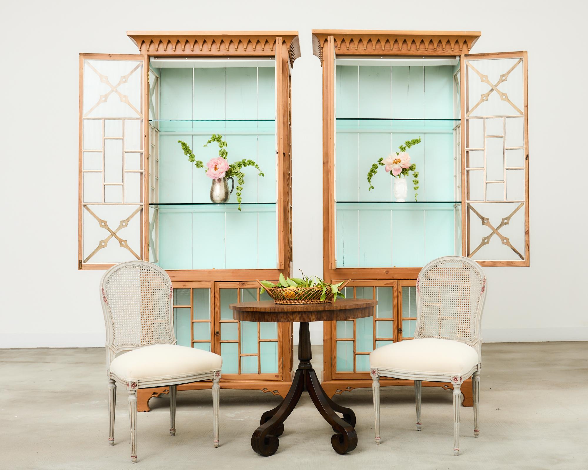 Gorgeous pair of English George III Style bookcases or display cabinet étagères decorated in the Chinese Chippendale taste. The cases are constructed from pine having a natural finish that showcases the rich, warm woodgrains throughout the pieces.