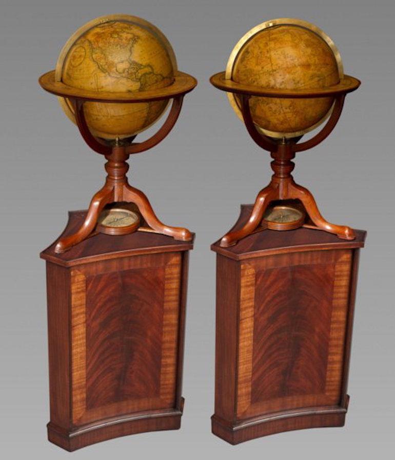 Each with brass meridian within rings applied with printed zodiac scales, raised on mahogany stands with curved brackets on ring turned columns and splayed tripod supports and pad feet joined by a stretcher centered by a compass. The terrestrial