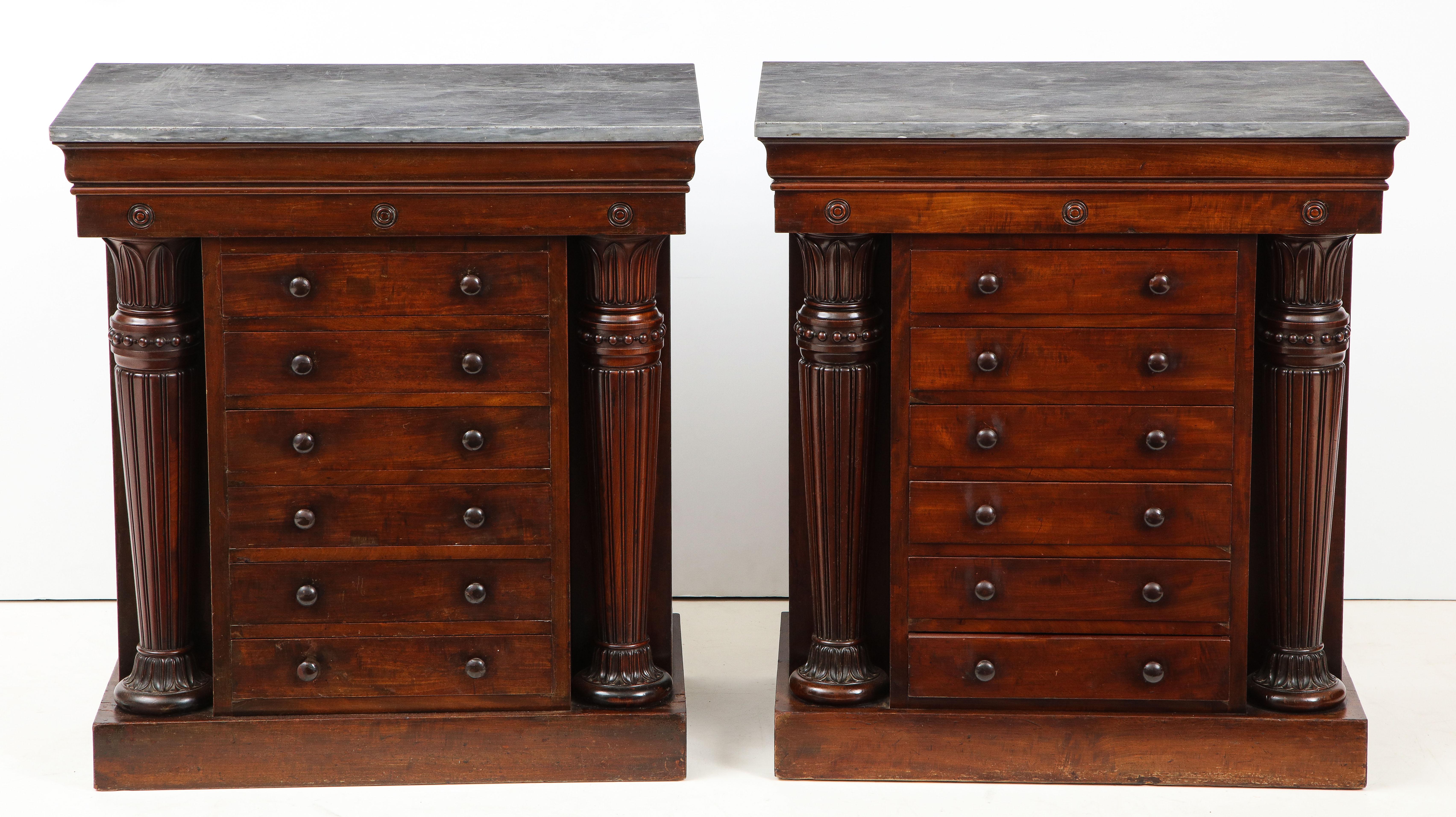 Fine pair of George IV collector’s cabinets in the Grecian manner popularized by Thomas Hope and George Smith having Santa Anna marble tops over frieze molding with applied bosses, over 6 drawers flanked by Egyptian influenced columns with long leaf