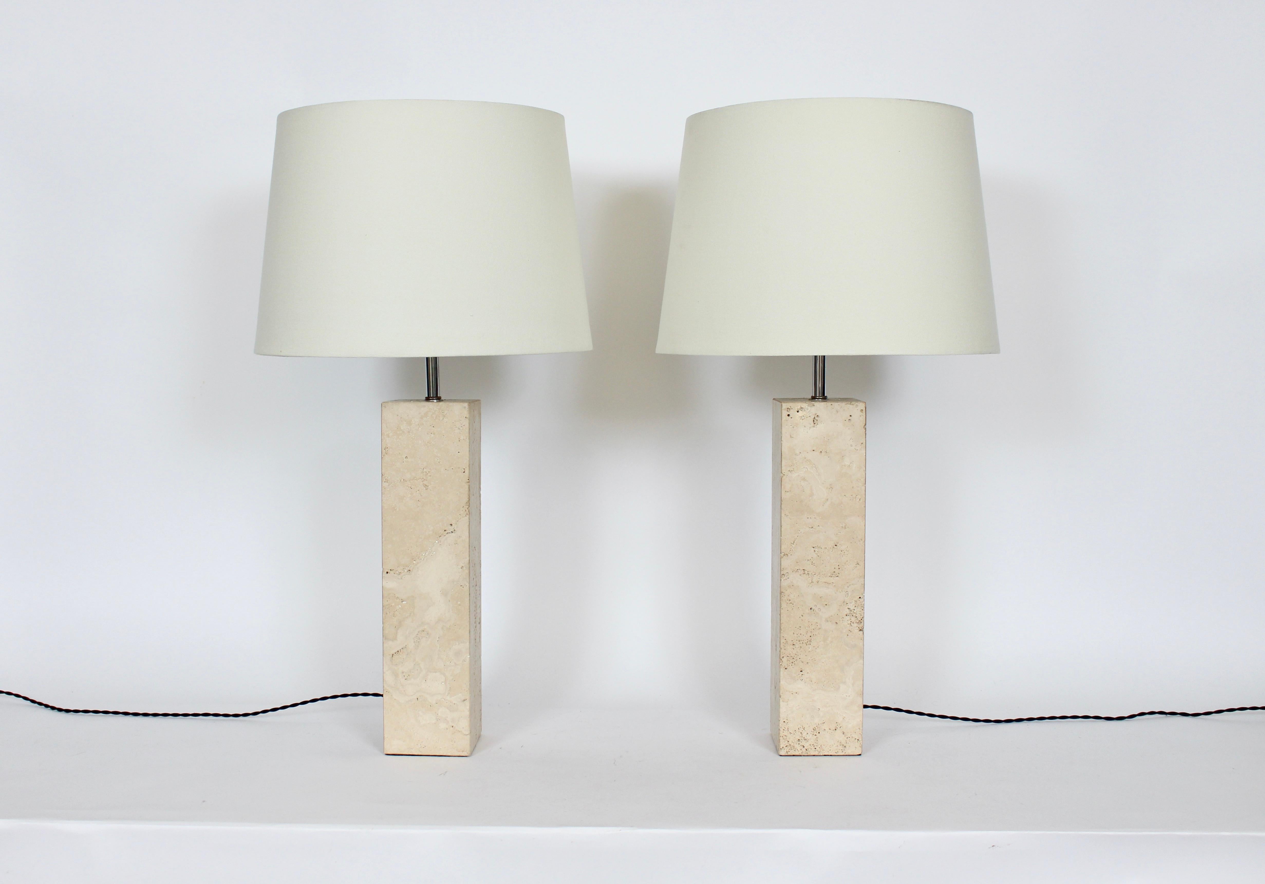 Pair of George Kovacs polished off white travertine table lamps, circa 1980. Featuring squared solid single piece tower forms in Cream toned natural, neutral Travertine, with cylindrical Chrome necks. 22H to top of socket. Travertine 16H. White lamp