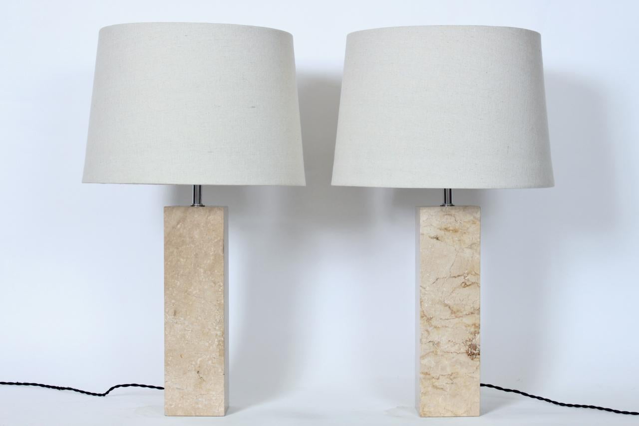 Pair of George Kovacs polished buff travertine table lamps, circa 1980. Featuring heavy, solid, squared single piece tower forms in Coffee Cream toned natural, neutral Travertine, with cylindrical Chrome necks. 19H to top of socket. Travertine 14H.