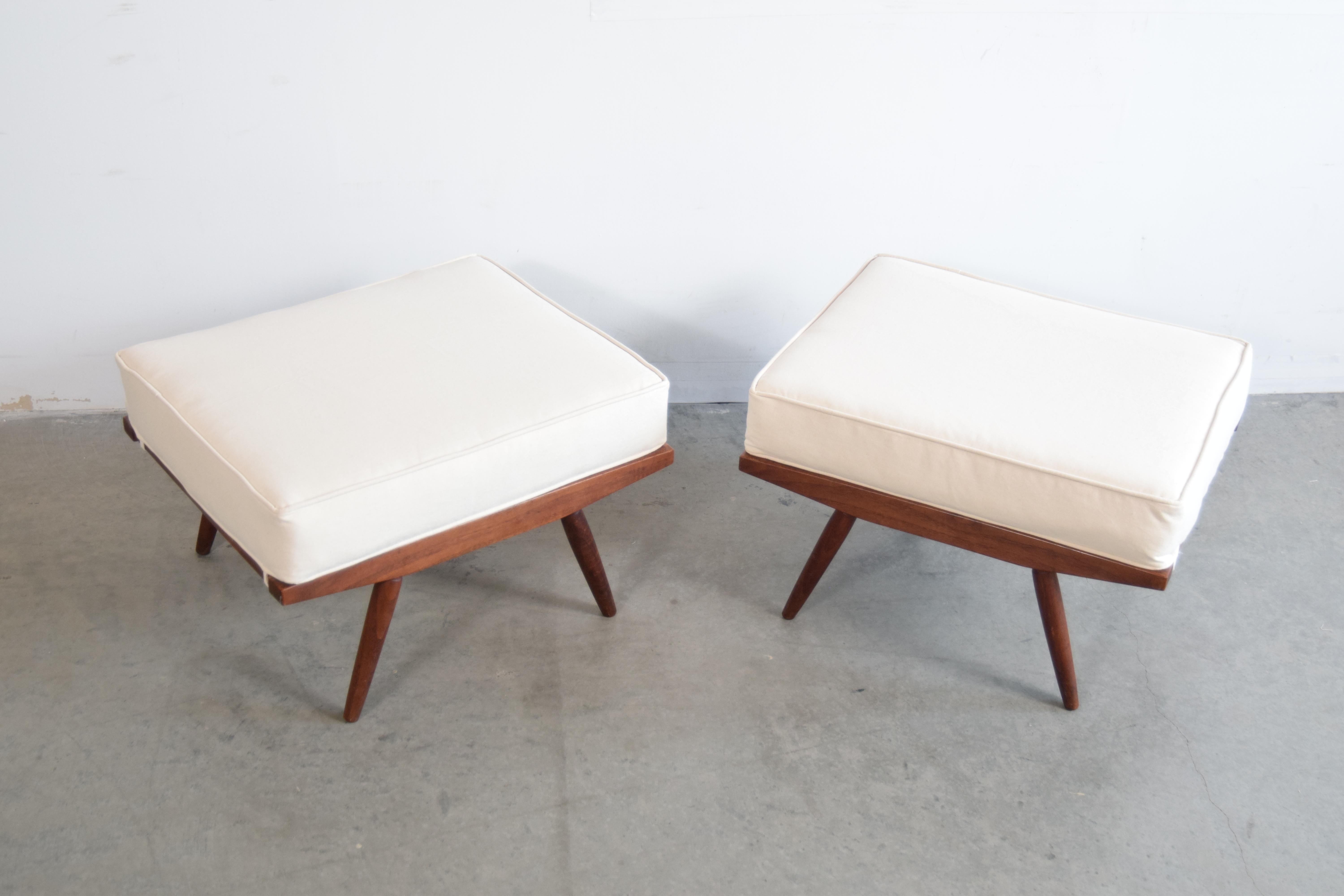Pair of George Nakashima (1905 - 1990) for Widdiicomb ottomans, circa 1958. Nakashima designed these as part of his 'Origins' line for Widdicomb. These have just been professionally re-upholstered in 100% organic cotton canvas. If you look closely