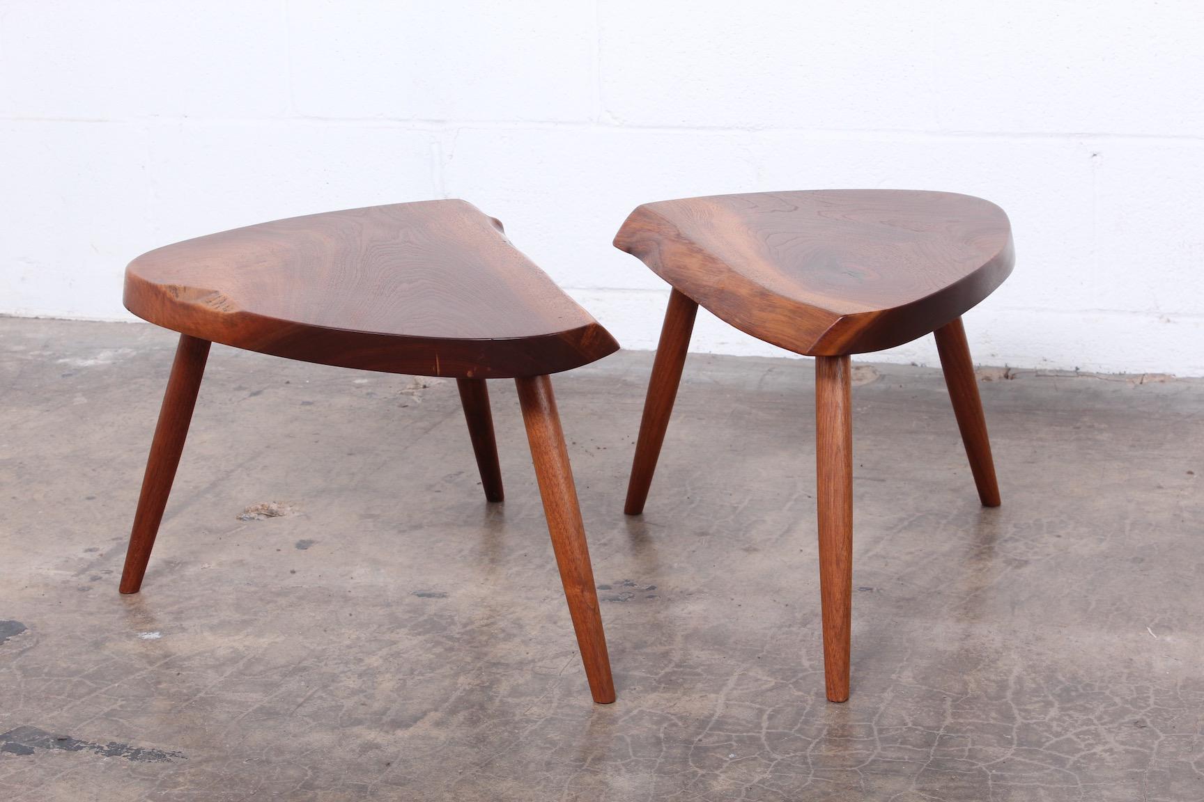 A pair of free edge, sap grain walnut tables / stools by George Nakashima, 1989.
  