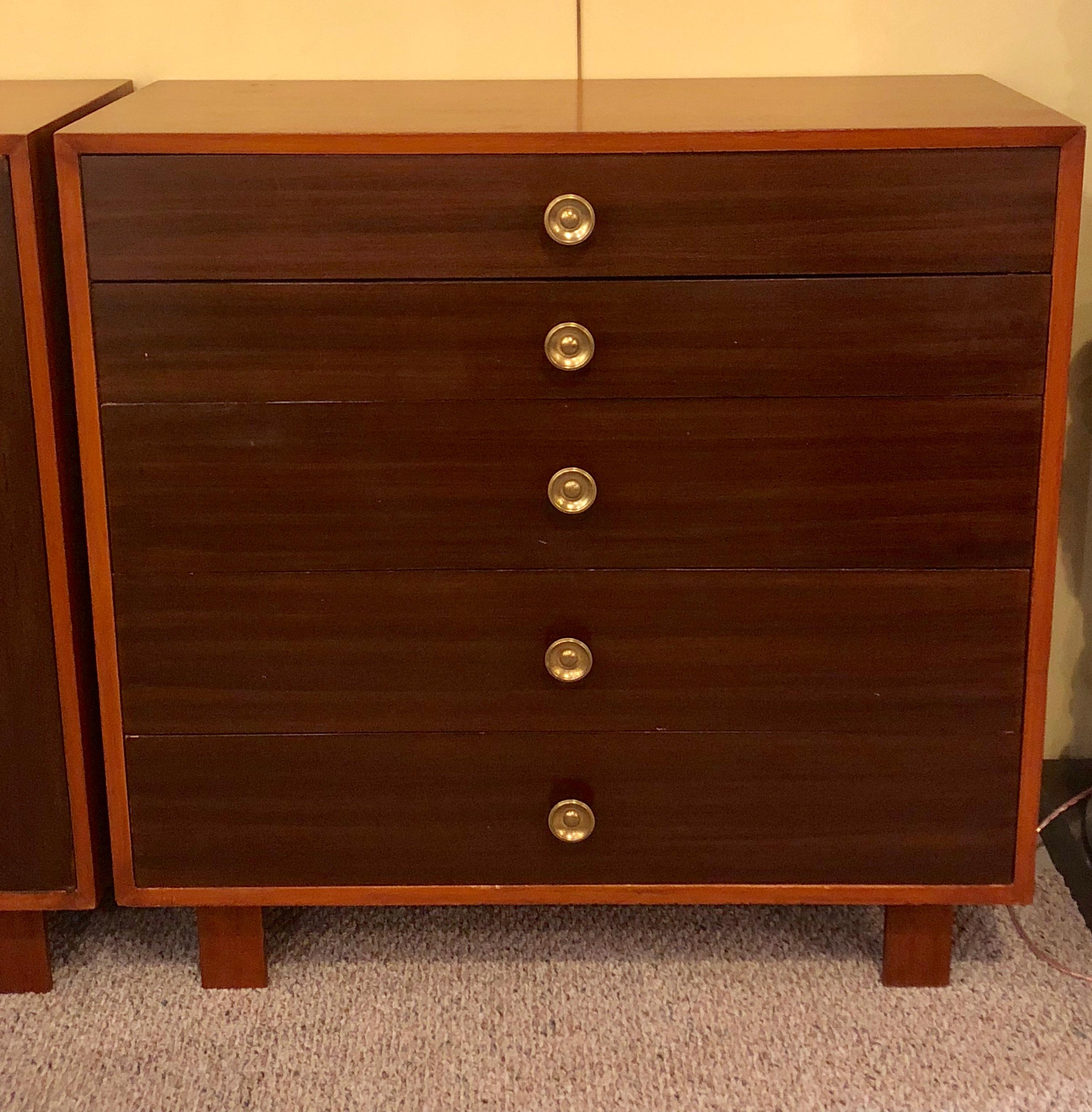A pair of Mid-Century Modern George Nelson design for Herman Miller chests / dressers / commodes. Signed with labels this pair of side by side and all drawer chests have mahogany fronts and walnut sides with brass pulls on bracket feet.