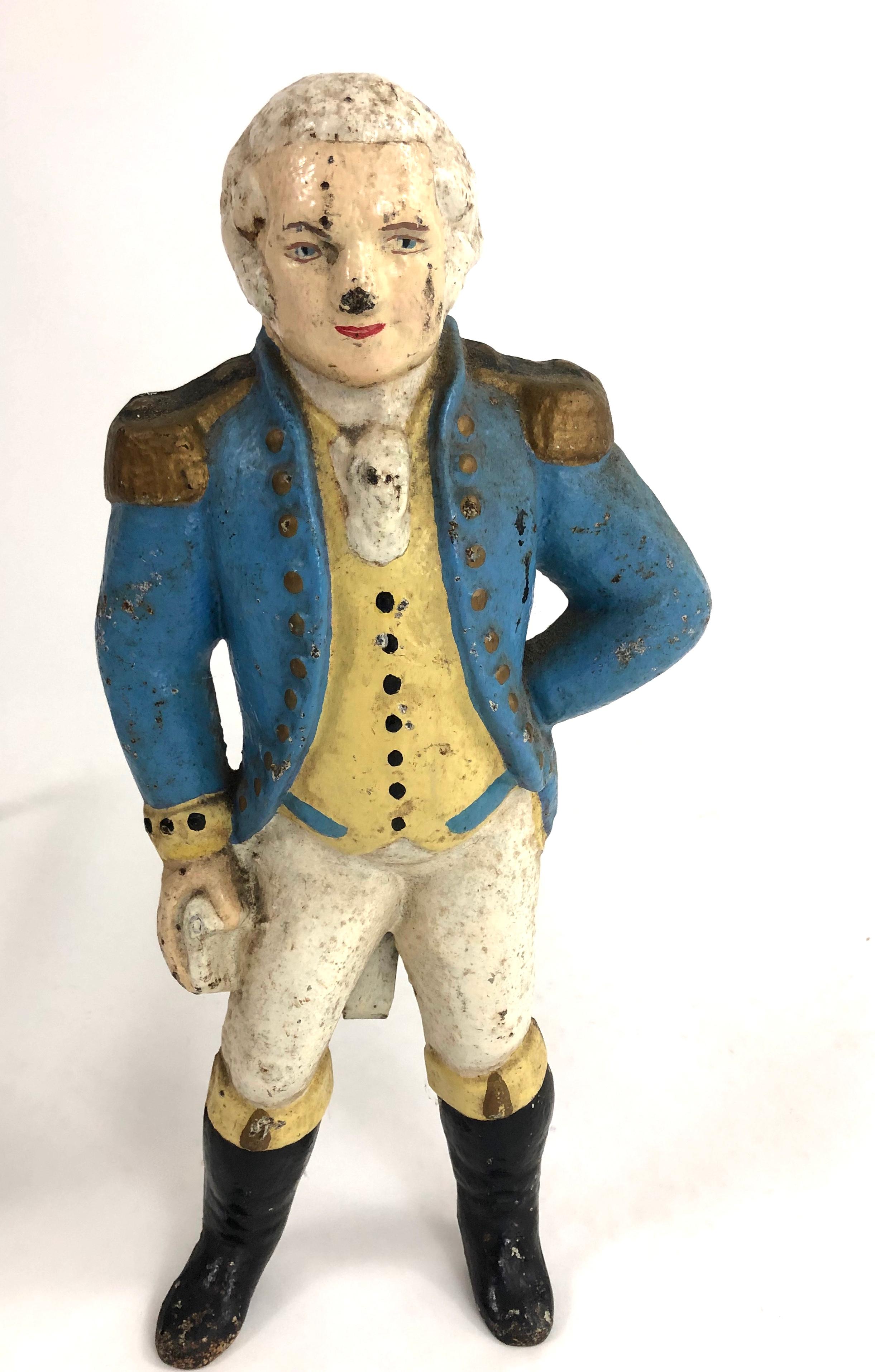 A pair of charming small scale figural George Washington cast iron andirons, retaining their original painted surface, which is uncommon, each with George Washington, wearing blue jacket with epaulettes, yellow buttoned vest, white britches and