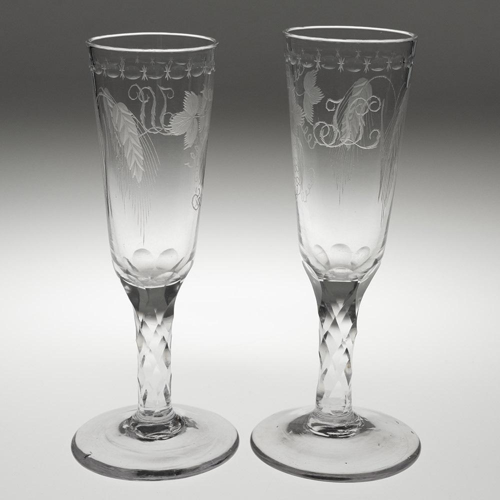 Heading : Pair of engraved Georgian ale glasses with facet cut stems
Period : George III – c1780
Origin : England
Colour : Clear
Bowl : Round funnel  engraved with hops and barley and monogram JLL. With OXO cutting to rim
Stem : Petal cut lower bowl