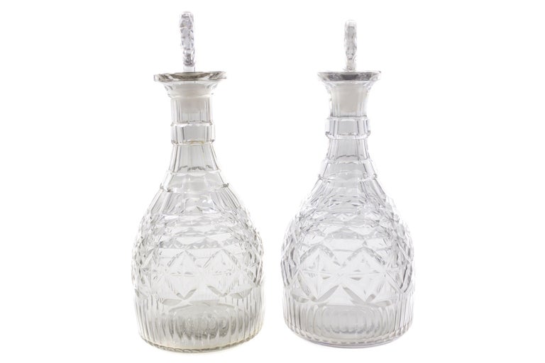 A fine pair of cut-glass wine decanters from the last quarter of the eighteenth-century, these likely are products of Ireland and exhibit expert facets across the glass that result in a wonderfully complex geometrical array. Starting in diamond